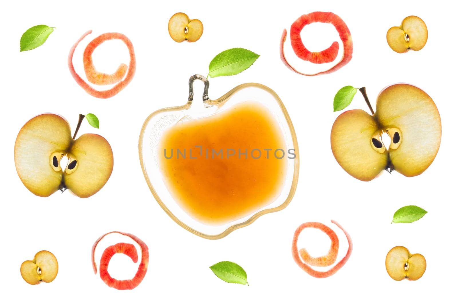 A small bowl with applesauce, apple slices, apple peels and leaves isolated backlit on a light table