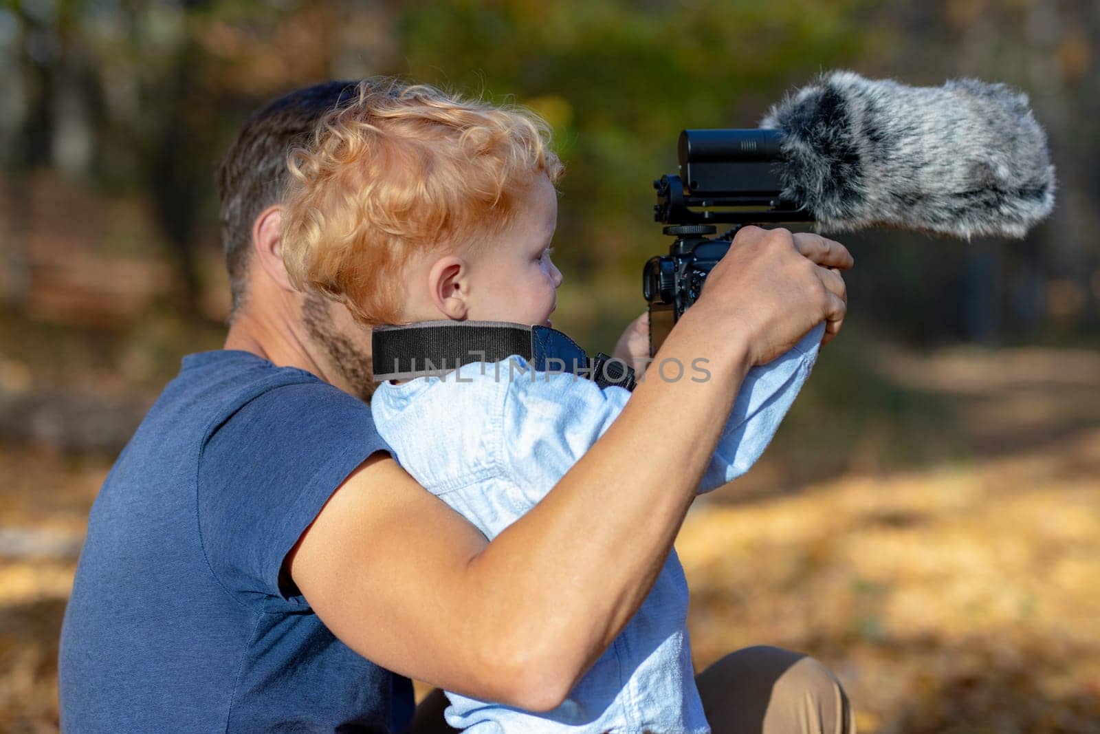 Dad carefully explaining to the curious child how the photo is taken with camera