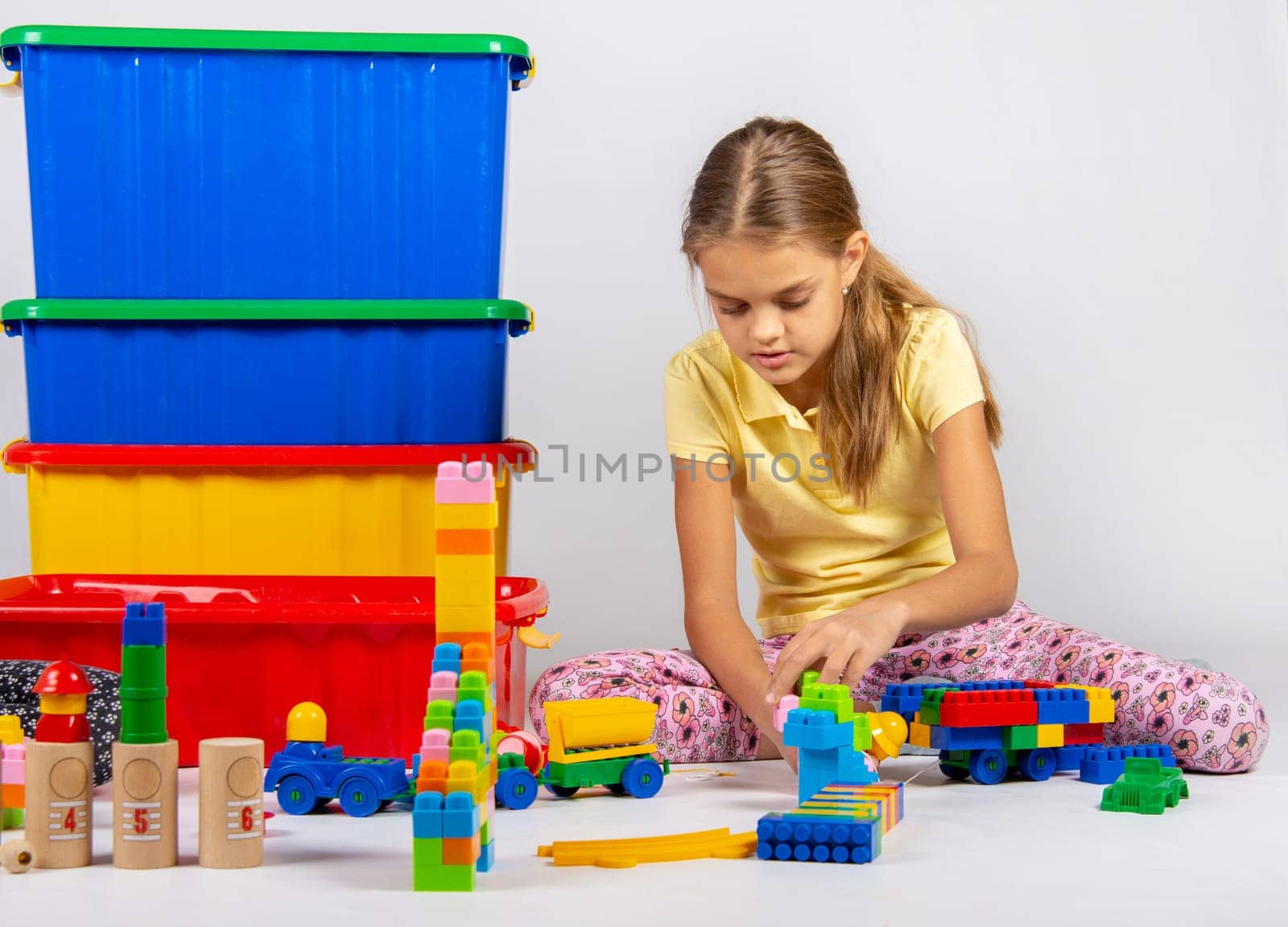 Ten year old girl playing toys sitting on the floor