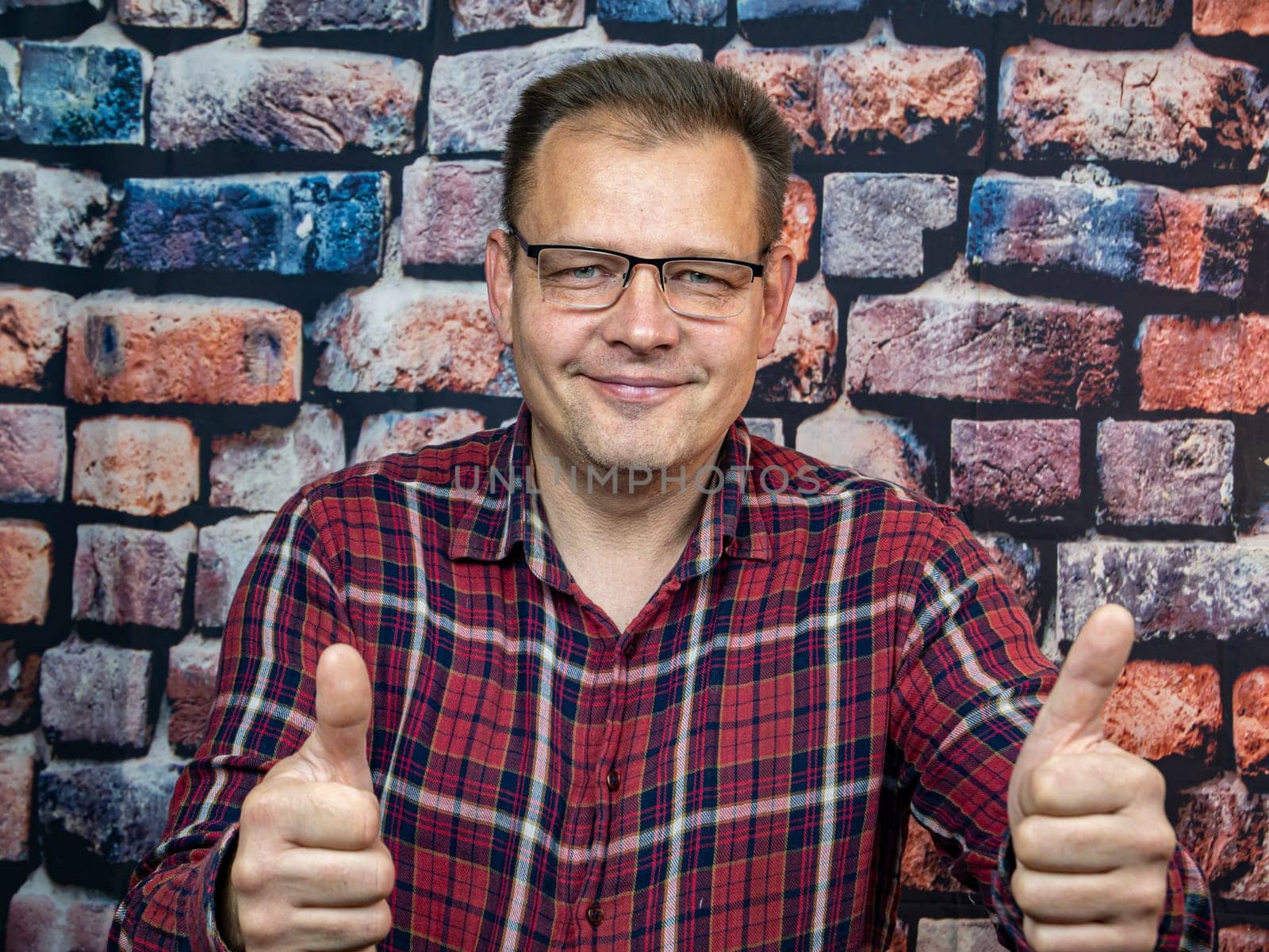 A man with glasses shows a good gesture. Symbols and gestures. Ok.