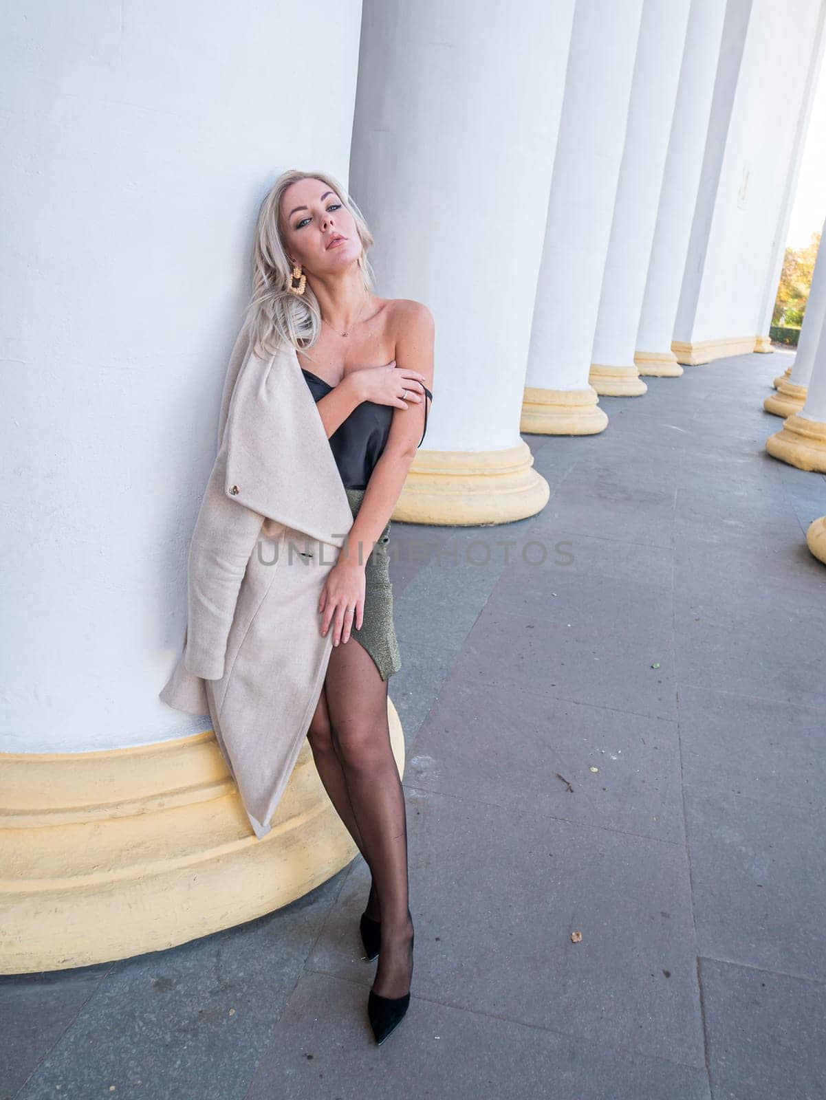 Blonde girl on a background of white columns. People. Background image.
