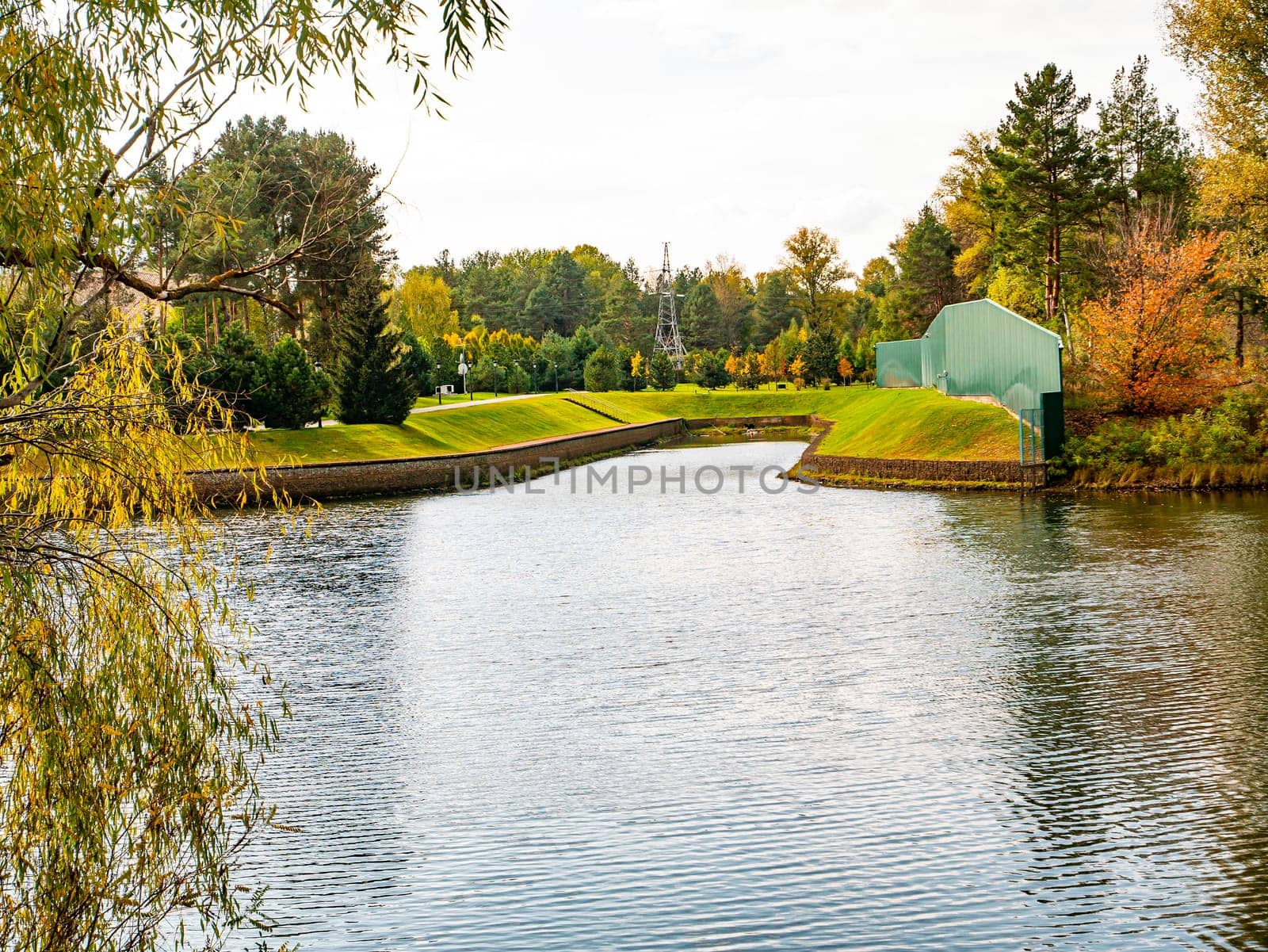 Autumn river landscape against a cloudy sky. Autumn foliage. Water. Background image. River bank.
