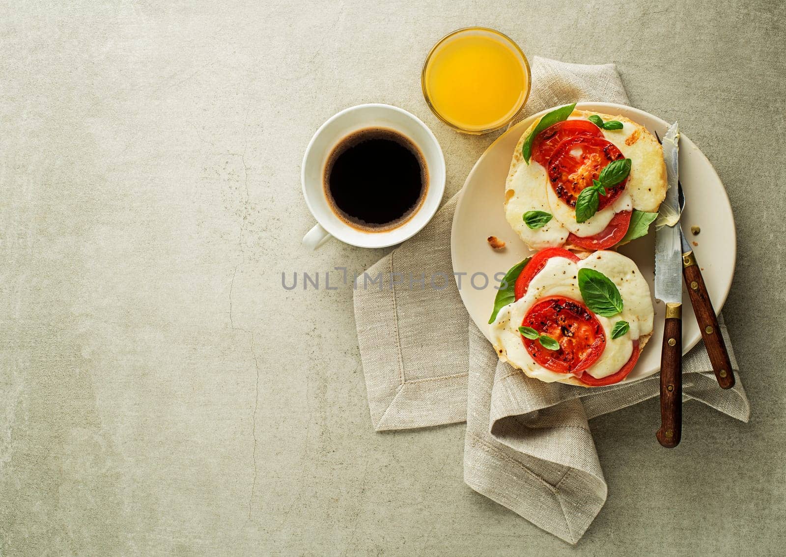 Breakfast served with mozzarella sandwich, juice and coffee on the table top view. Healthy breakfast food.