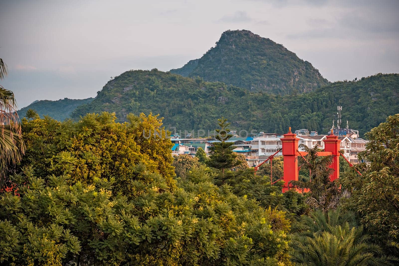 Red bridge on Sanduo Lu street in Guilin town city with karst mountains in the background, Guangxi Province, China