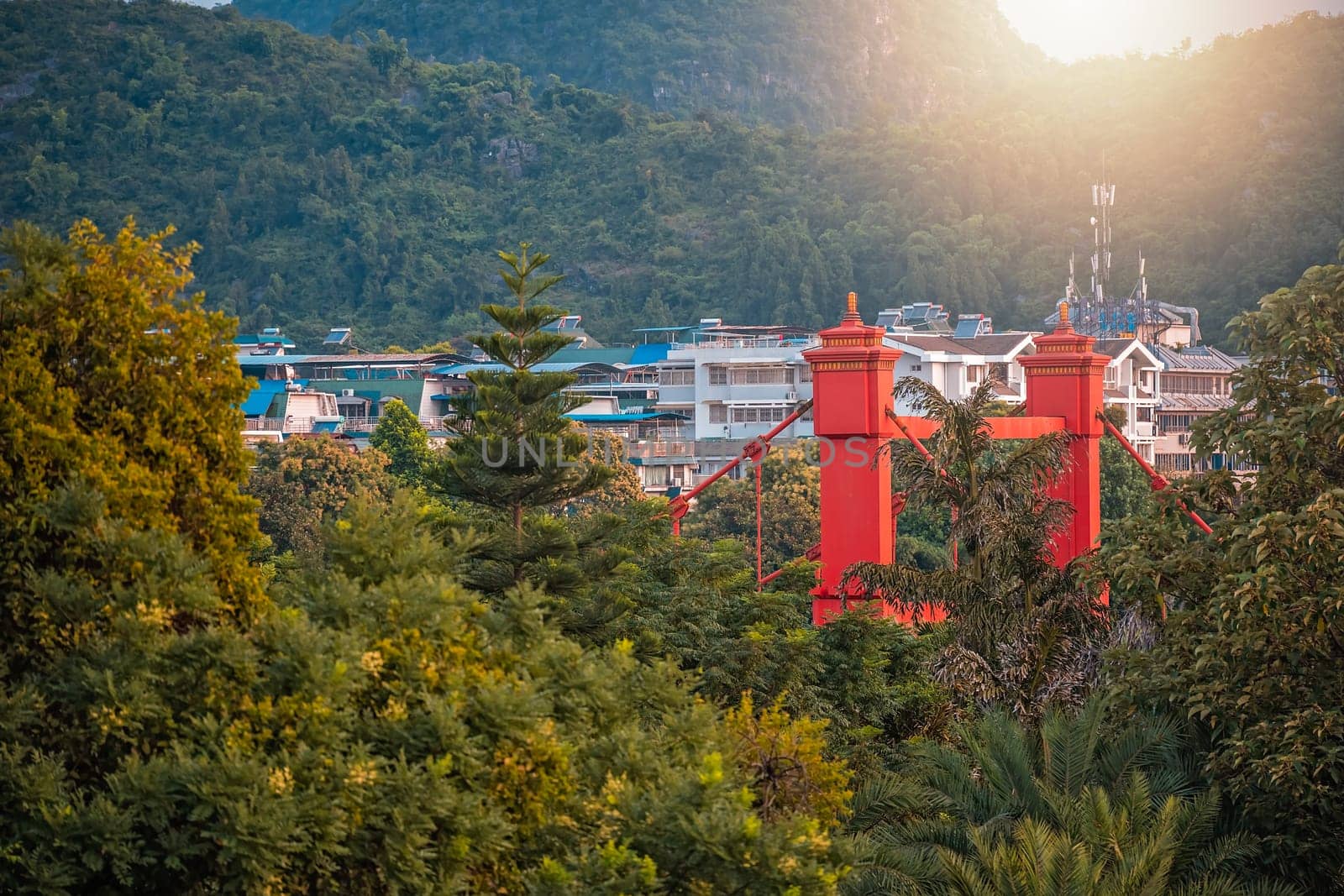 Red bridge on Sanduo Lu street in Guilin town city with karst mountains in the background, Guangxi Province, China