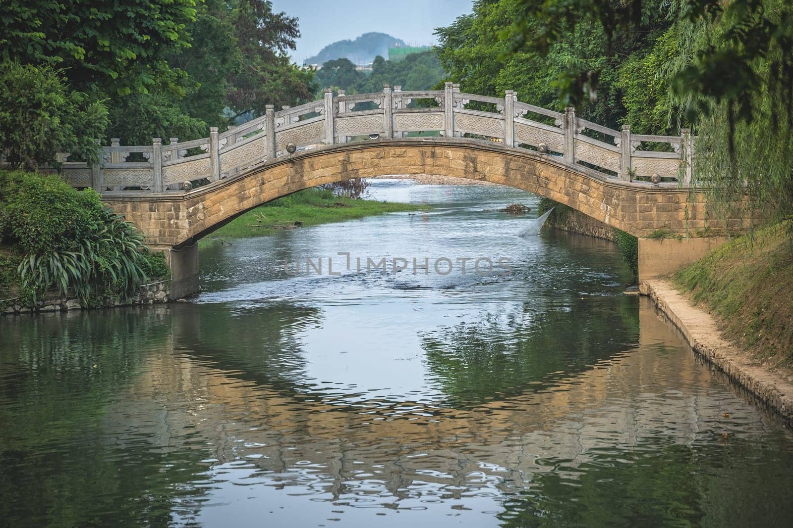 Small arched old bridge on Li River in Elephant Trunk Hill park in Guilin town, Guangxi Province, China
