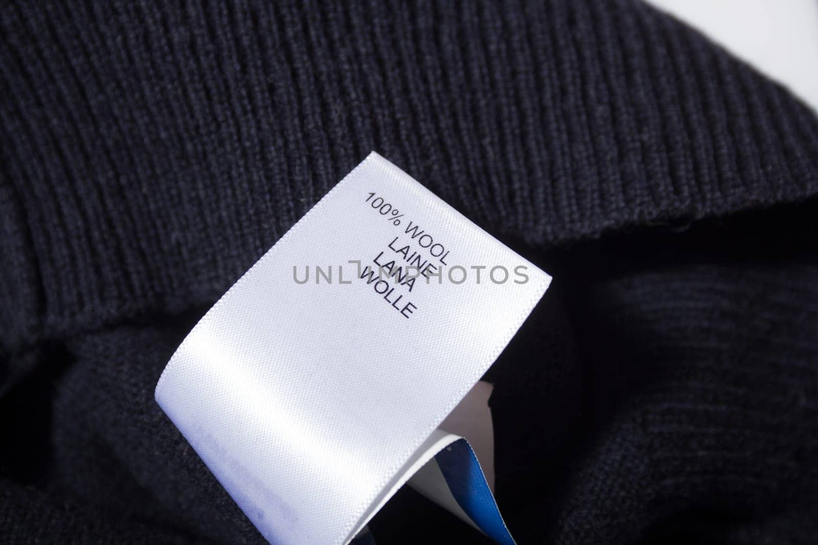 100 wool label on the sweater dark blue wool fabric.