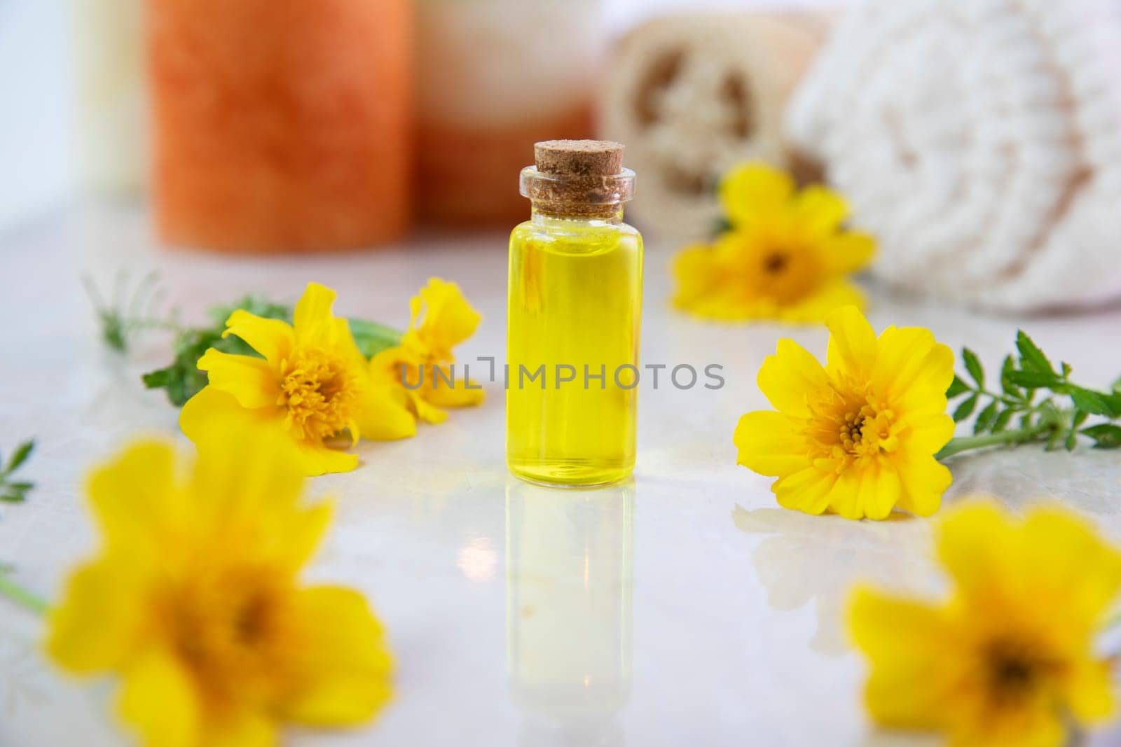 Flower essence in a small bottle with fresh marigold flower