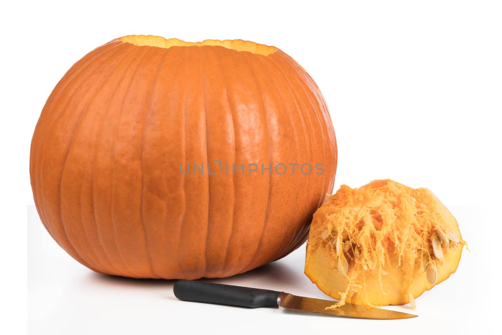 Pumpkin with top removed and knife isolated on a white background