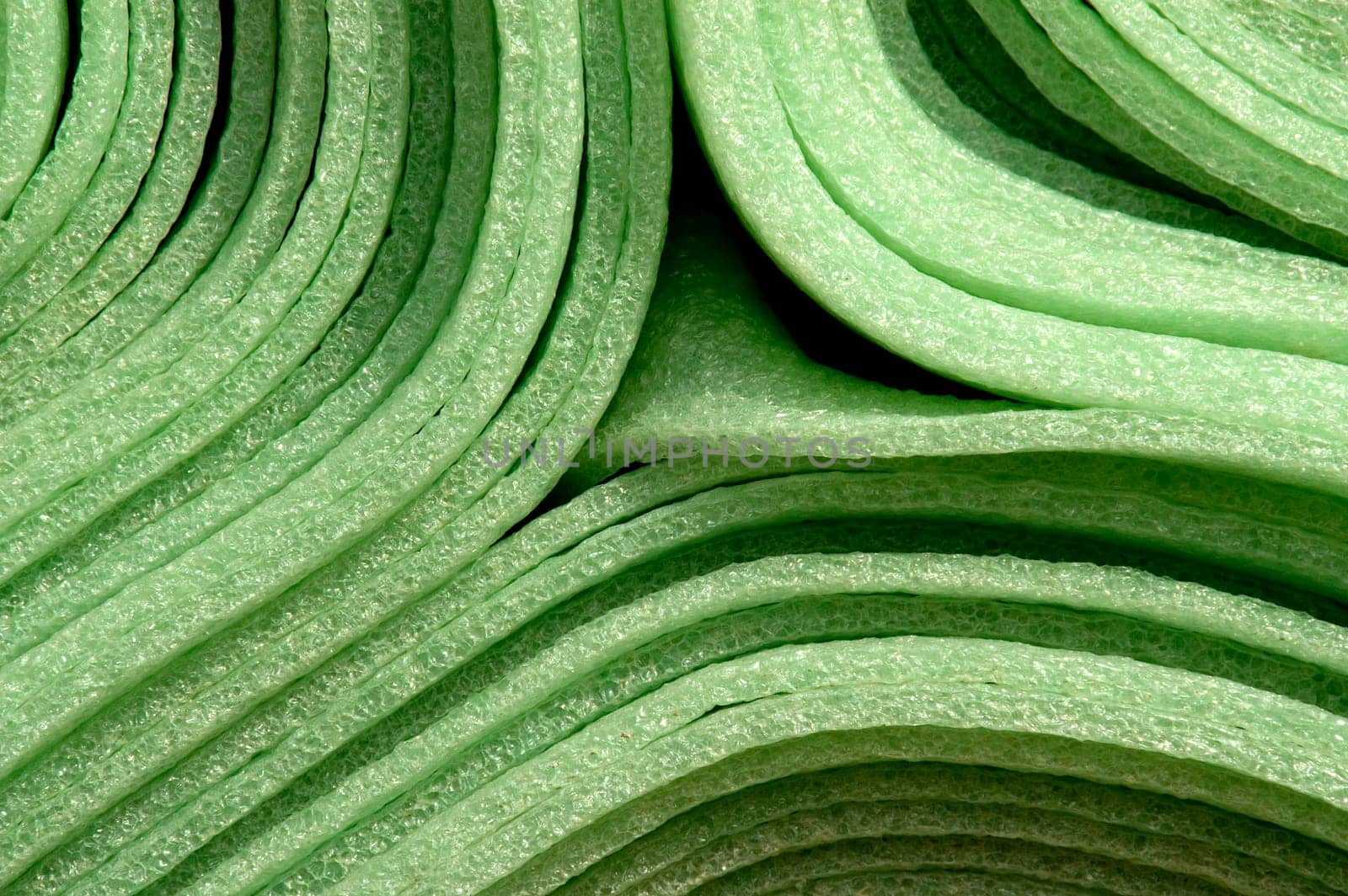Close up of rolled up green foam material mats for construction purpose.
