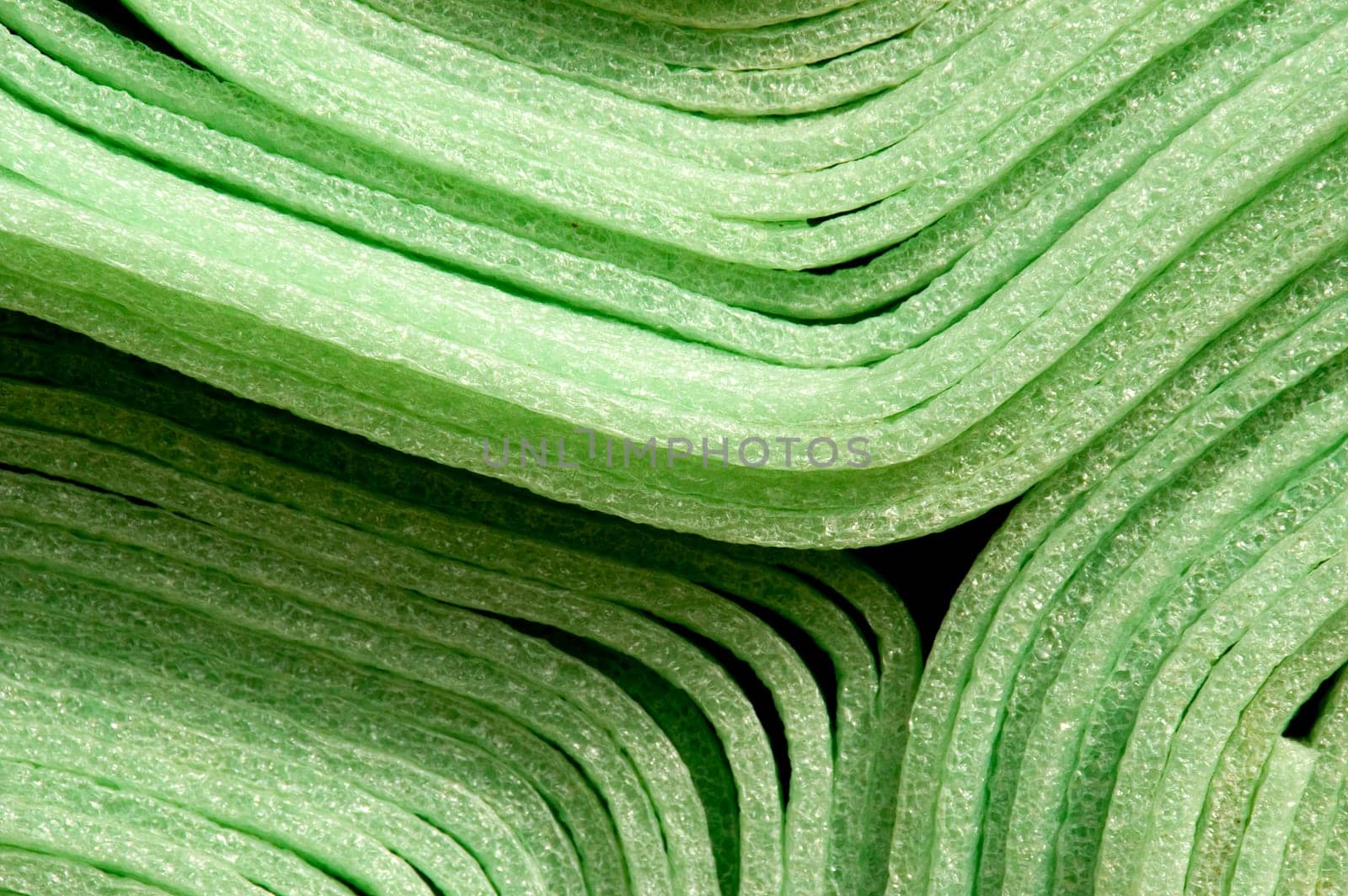 Close up of rolled up green foam material mats for construction purpose.