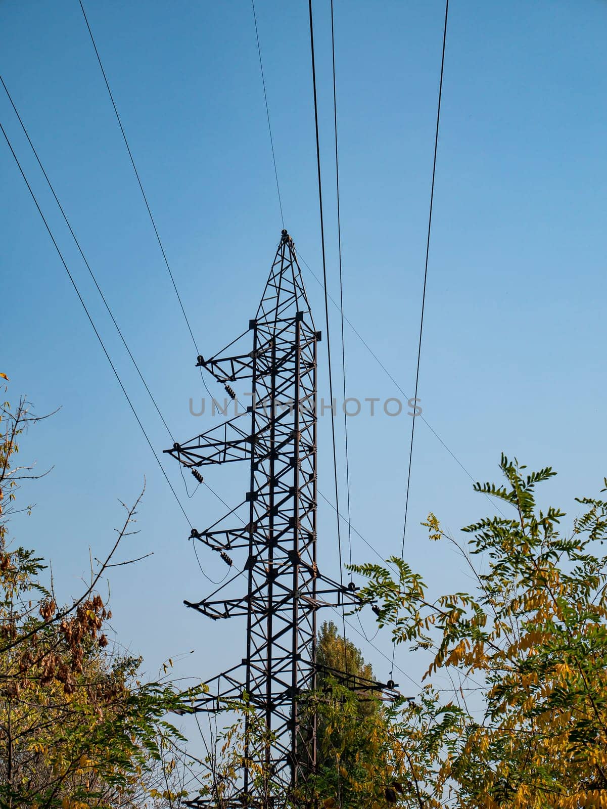 High voltage power line against the blue sky. Industrial landscape. Place for text.