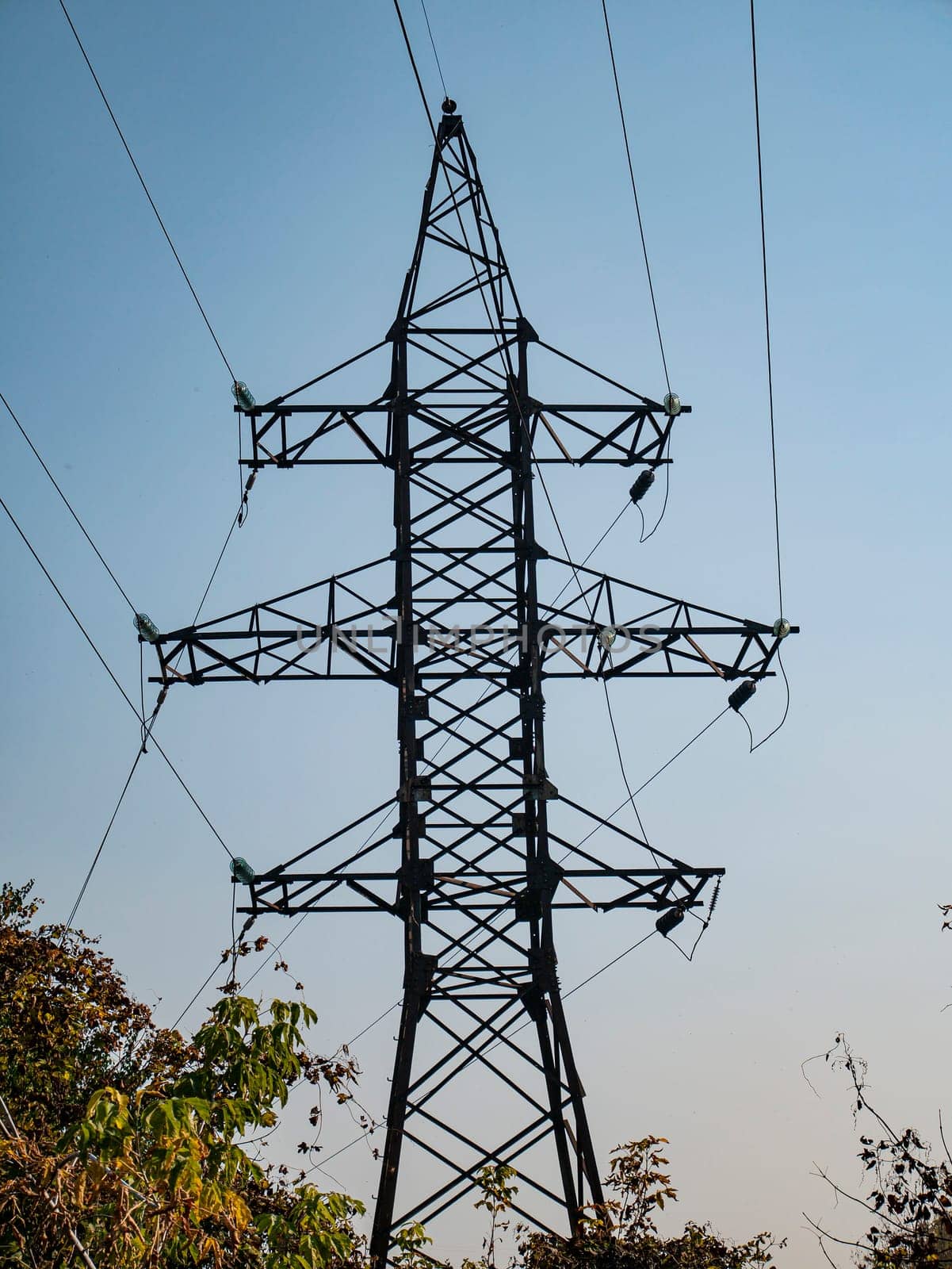 High voltage power line against the blue sky. Industrial landscape. Place for text.