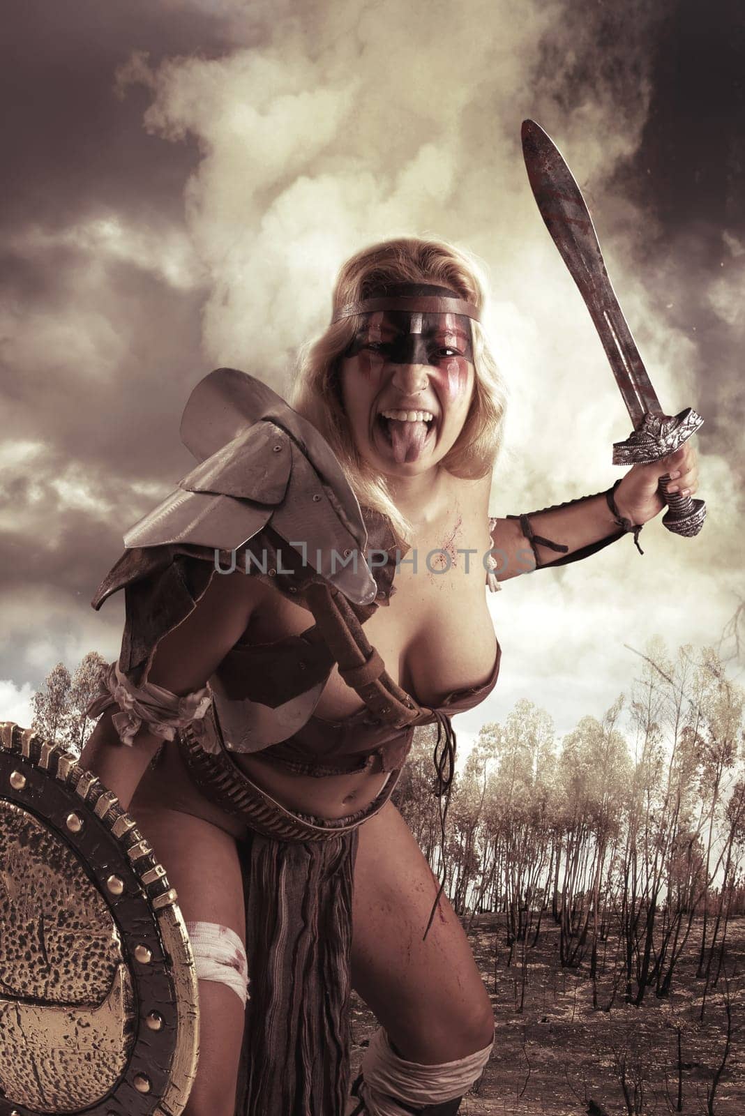 Ancient woman warrior or Gladiator posing outdoors with sword and shield