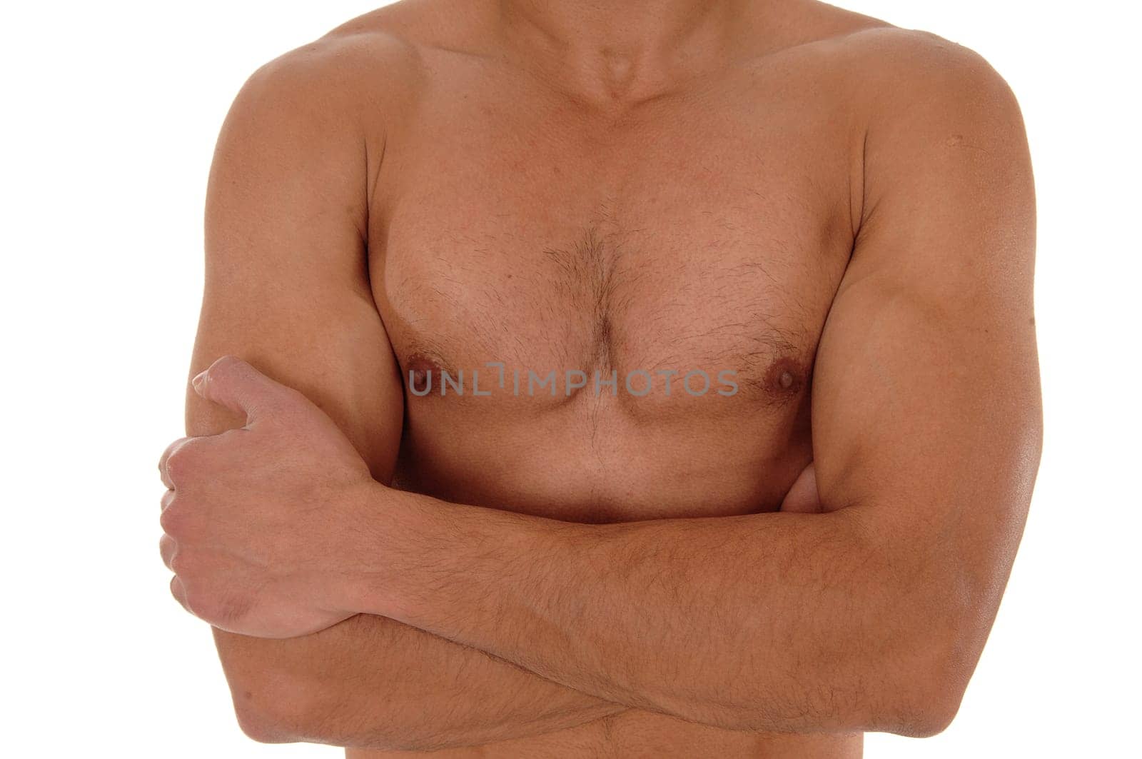 A close up image of the chest of a young handsome man with his arms.crossed, isolated for white background.