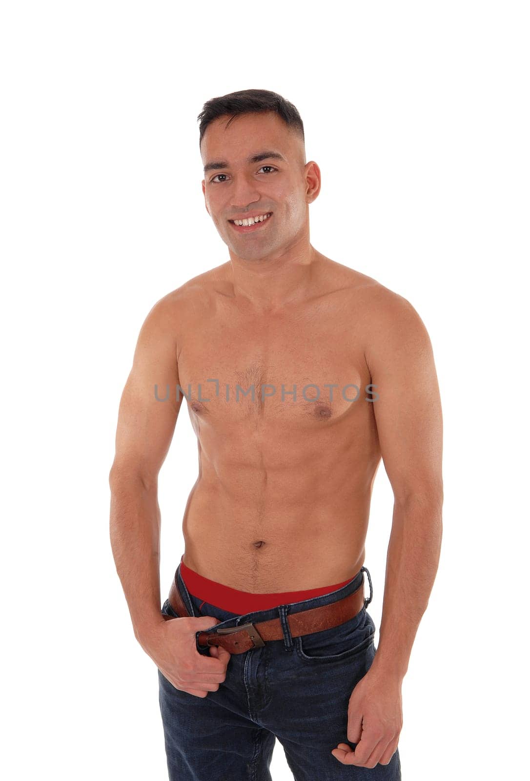 A handsome young east Indian man standing shirtless and smiling.in jeans with red underwear, isolated for white background.