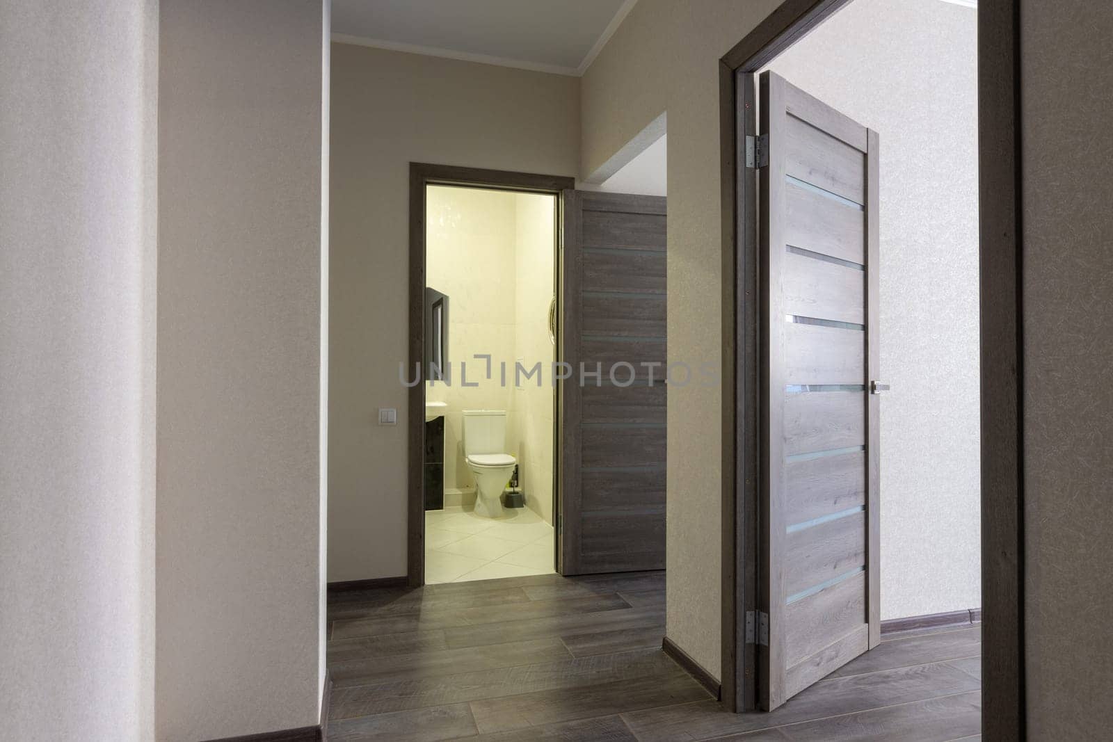 Corridor in a small apartment, open doors to the bathroom and room