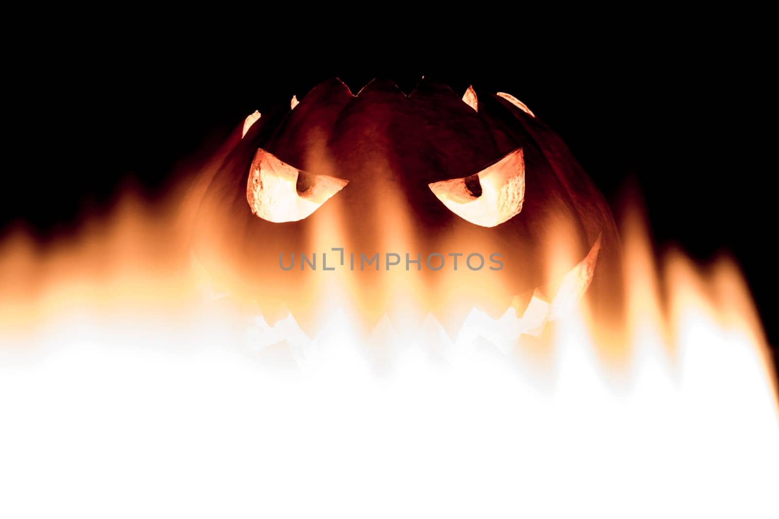 Big helloween autumn symbol with mad face, glowing eyes, mouth and teeth. Scary hot nightmare horror with evil smile at october 31st.