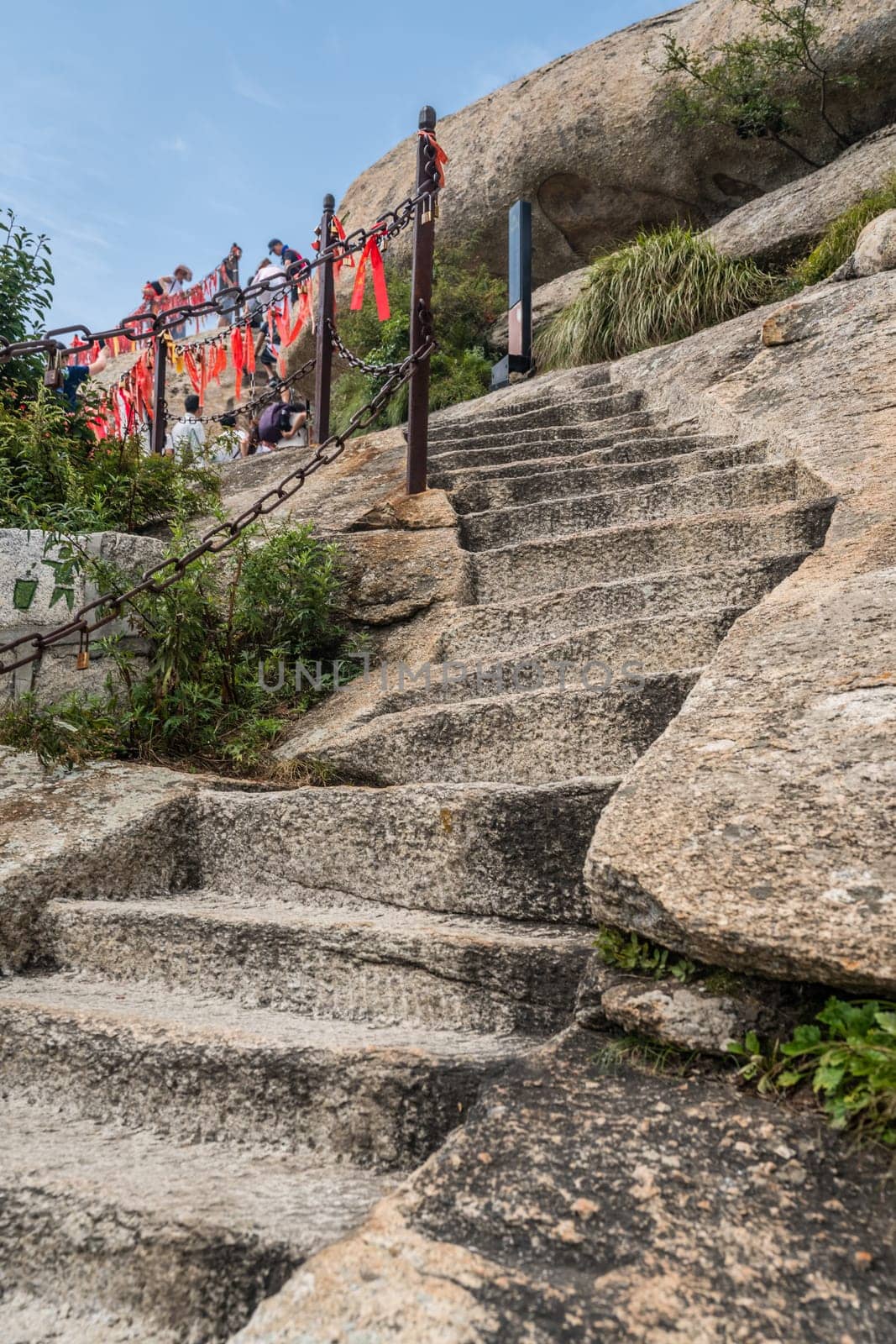 Huashan, China -  August 2019 : Cut in a rock stone stair steps leading to the summit of a West Peak on Huashan mountain, Xian, Shaanxi Province
