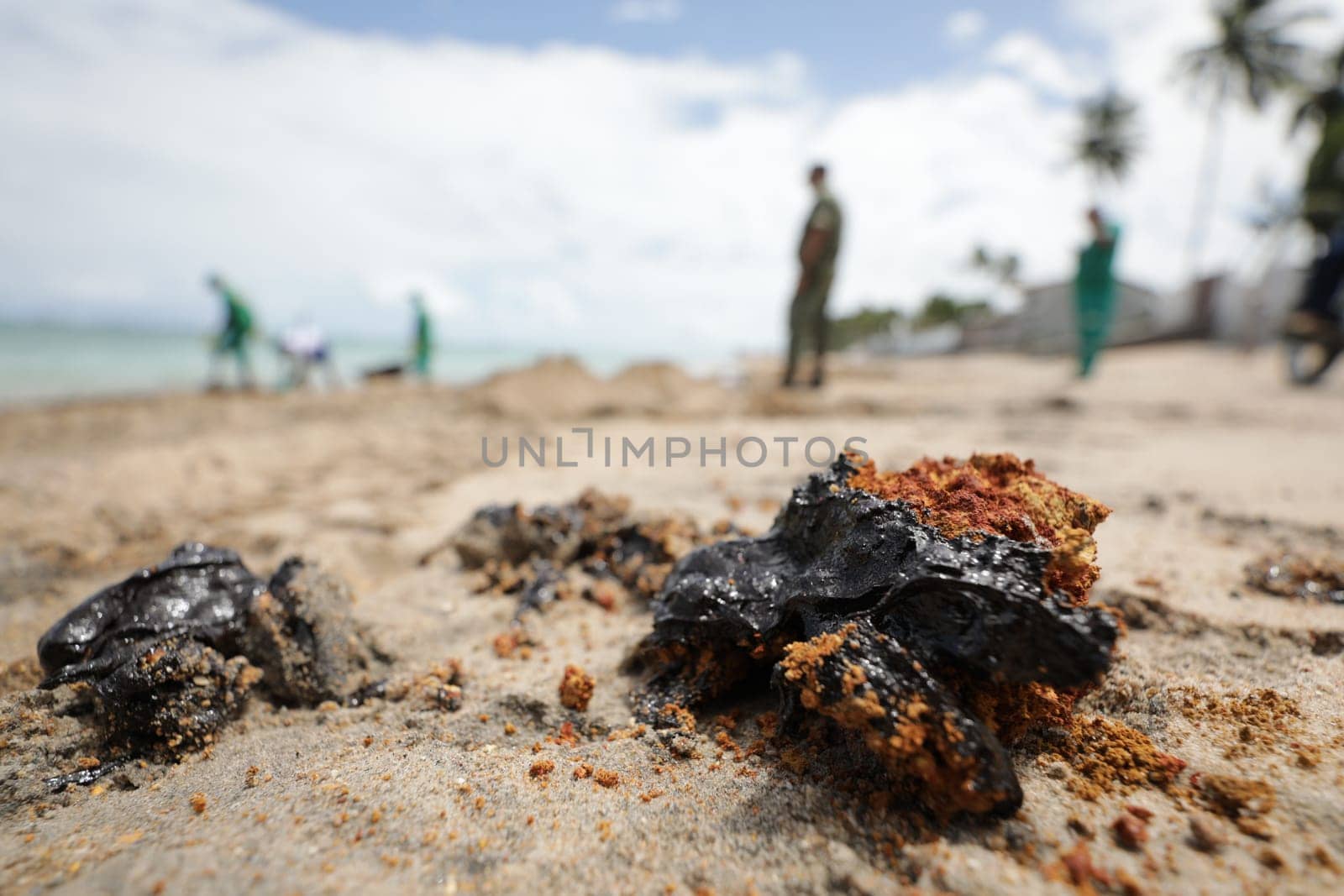 VERA CRUZ, BAHIA / BRAZIL - OCTOBER 18, 2019: People collect oil slick in Praia do Sol, the place was affected by the oil spill in the sea (Joa Souza / Panthermedia).