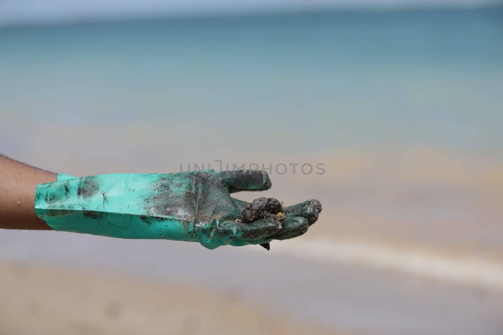 VERA CRUZ, BAHIA / BRAZIL - OCTOBER 18, 2019: People collect oil slick in Praia do Sol, the place was affected by the oil spill in the sea (Joa Souza / Panthermedia).