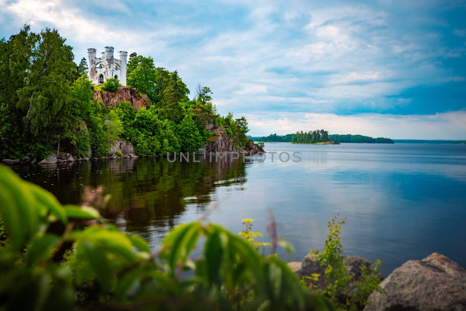 Old white house on cliff over lake. Travel in Russia, old architecture.