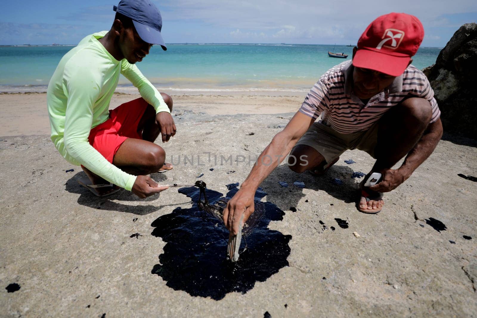 VERA CRUZ, BAHIA / BRAZIL - October 18, 2019: People obsessed with oil macha on Sol Beach, the place was affected by oil spills at sea (Joa Souza / Panthermedia).