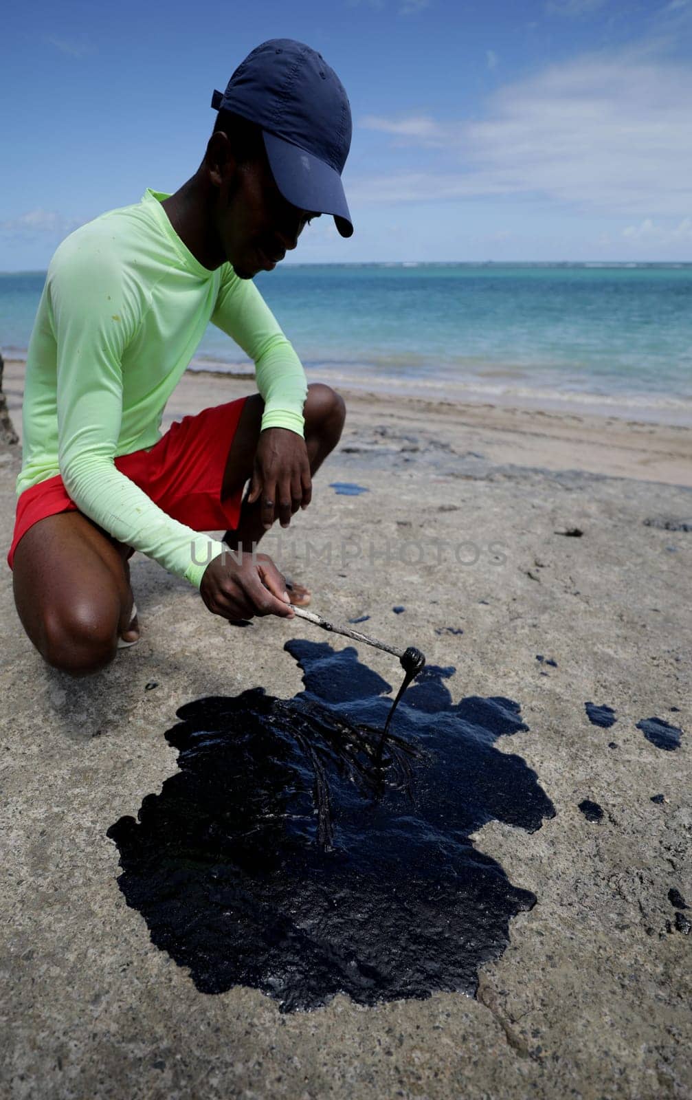 VERA CRUZ, BAHIA / BRAZIL - October 18, 2019: People obsessed with oil macha on Sol Beach, the place was affected by oil spills at sea (Joa Souza / Panthermedia).