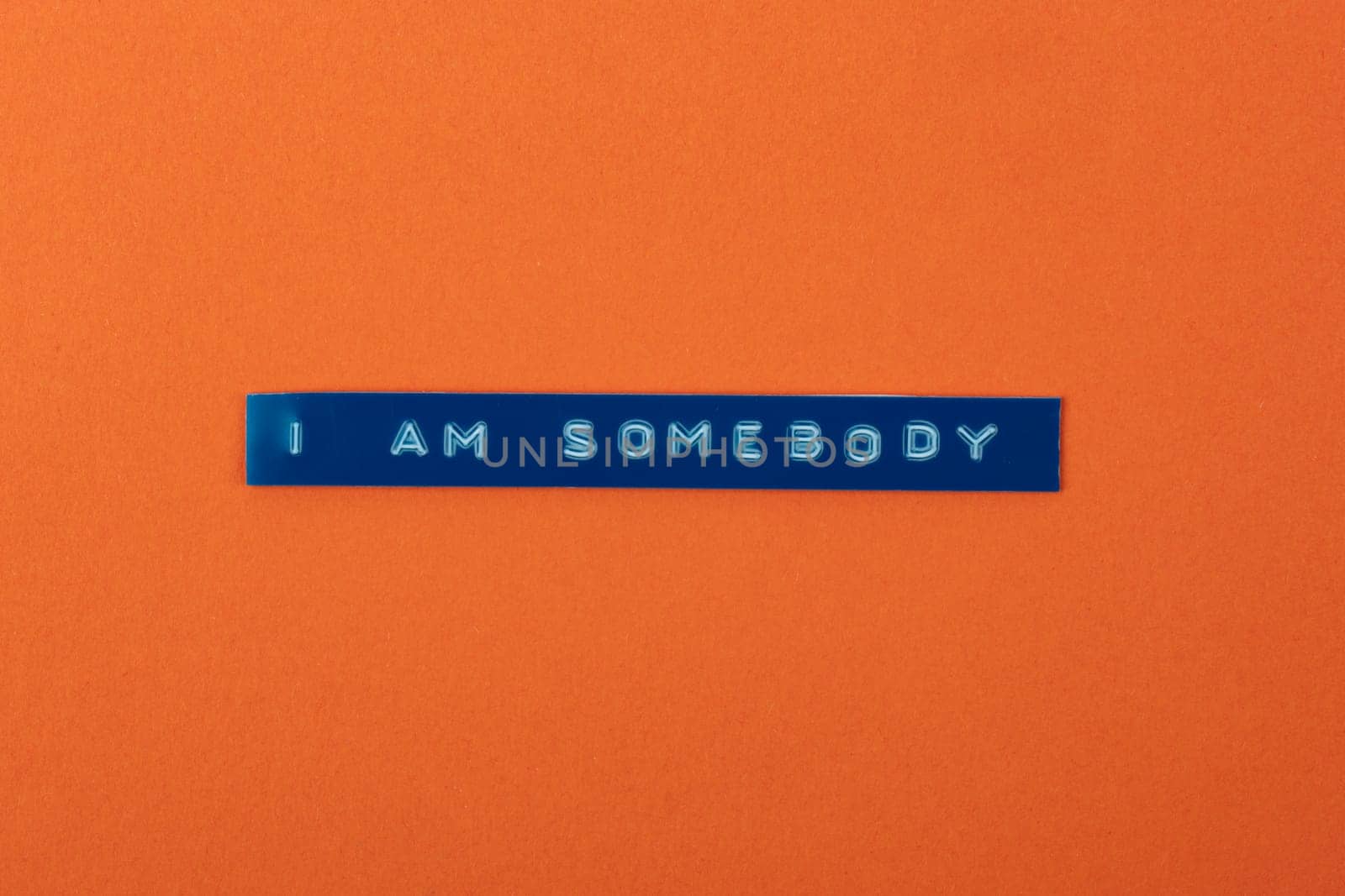I am Somebody text with a labelprinter on orange cardboard