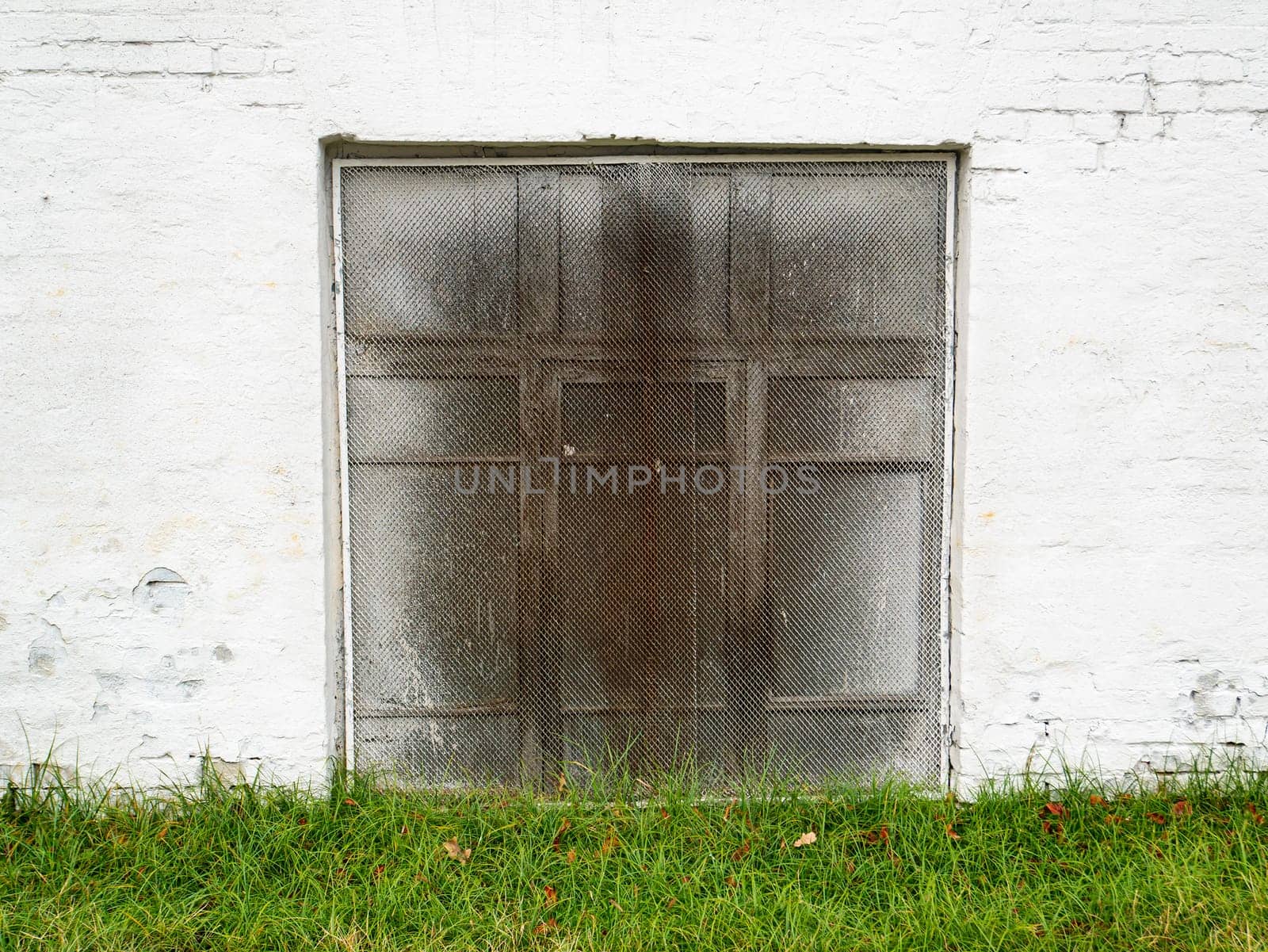 Window with a lattice in a white wall. Place for text. Background image.