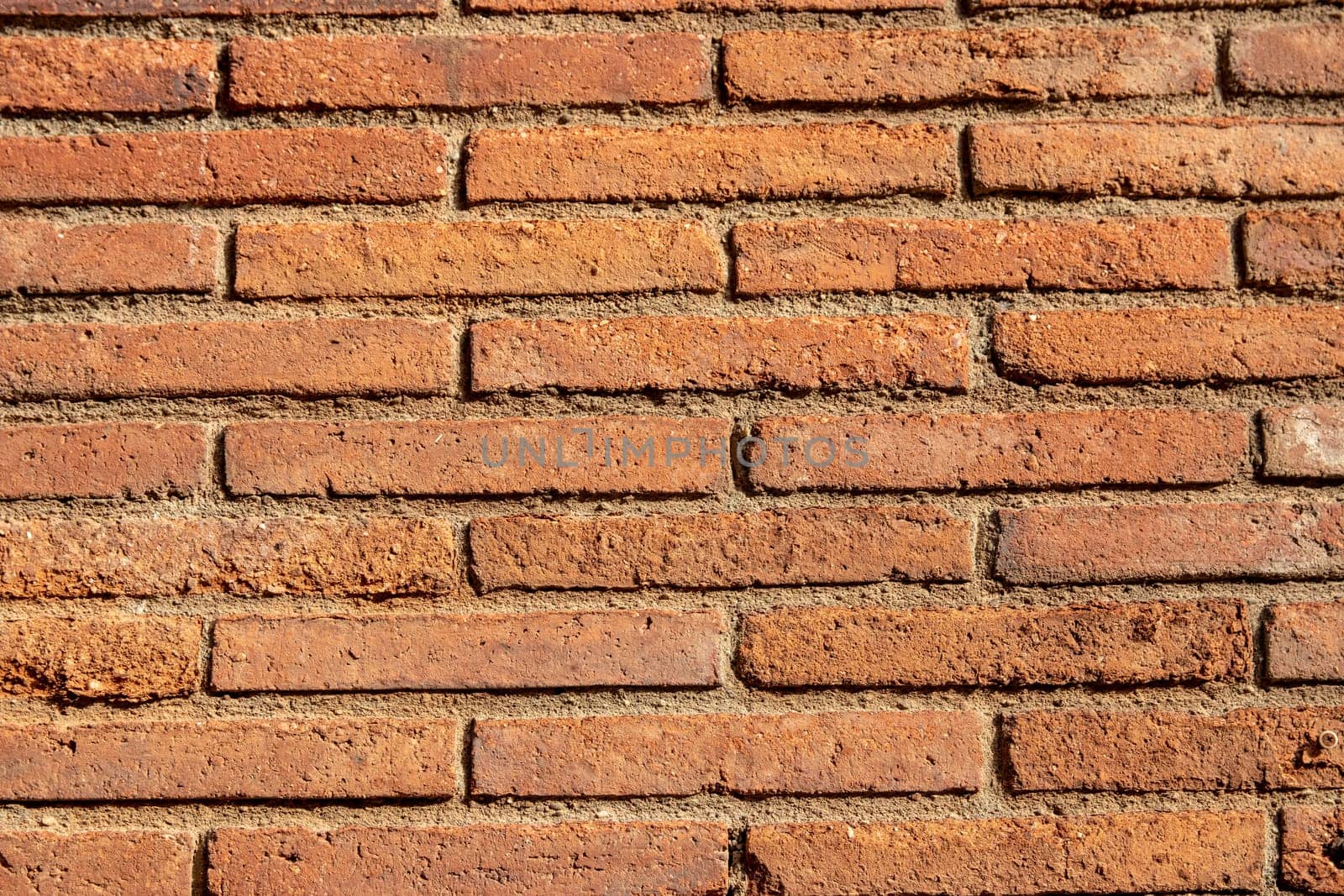 Stone texture background. Closeup of a old red brown of a weathered brick wall texture with a hilly uneven surface. Abstract background concept.