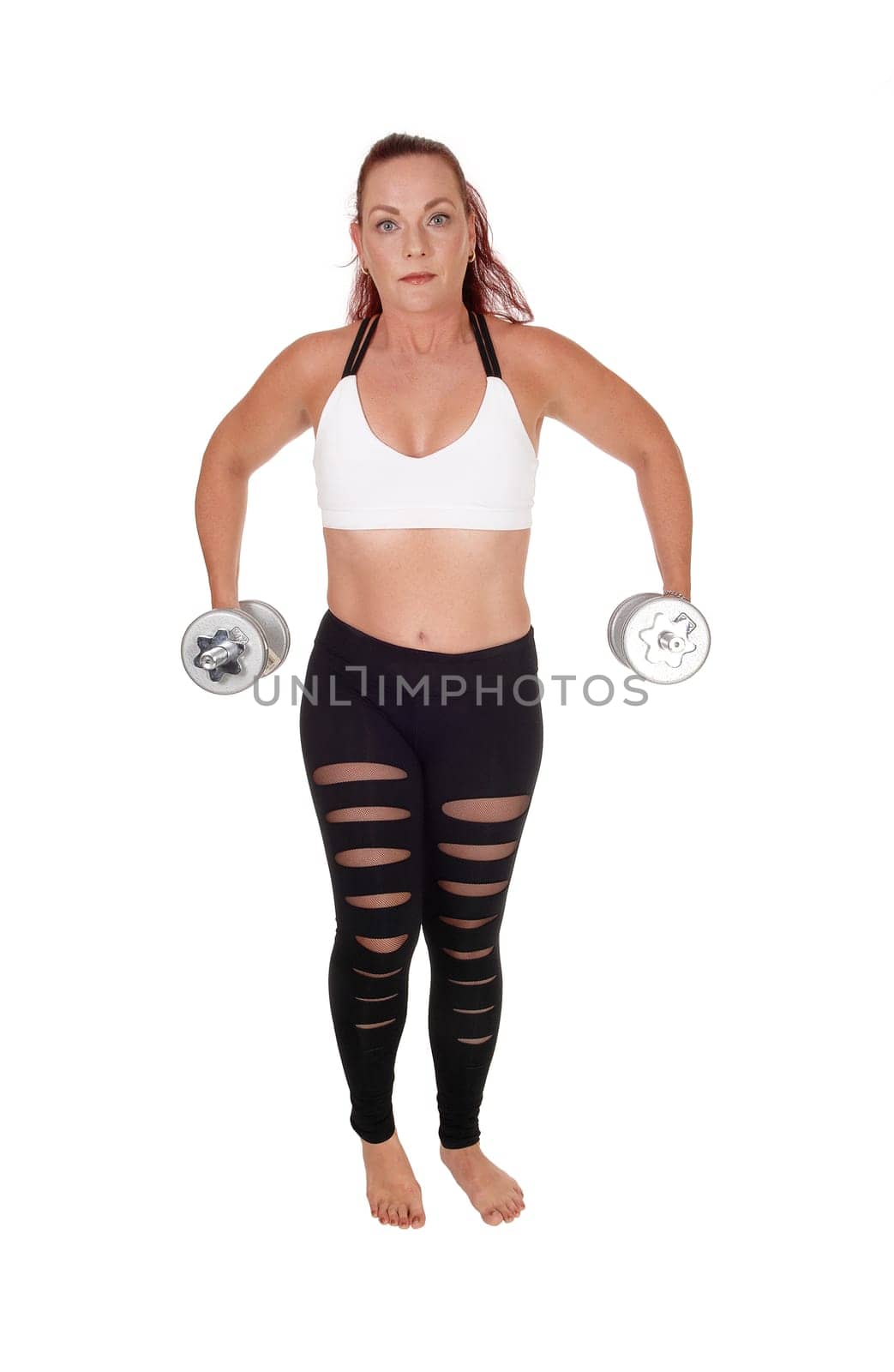 An exercising pretty woman standing in workout outfits and lifting.up the two dumbbells in her hand, isolated for white background.