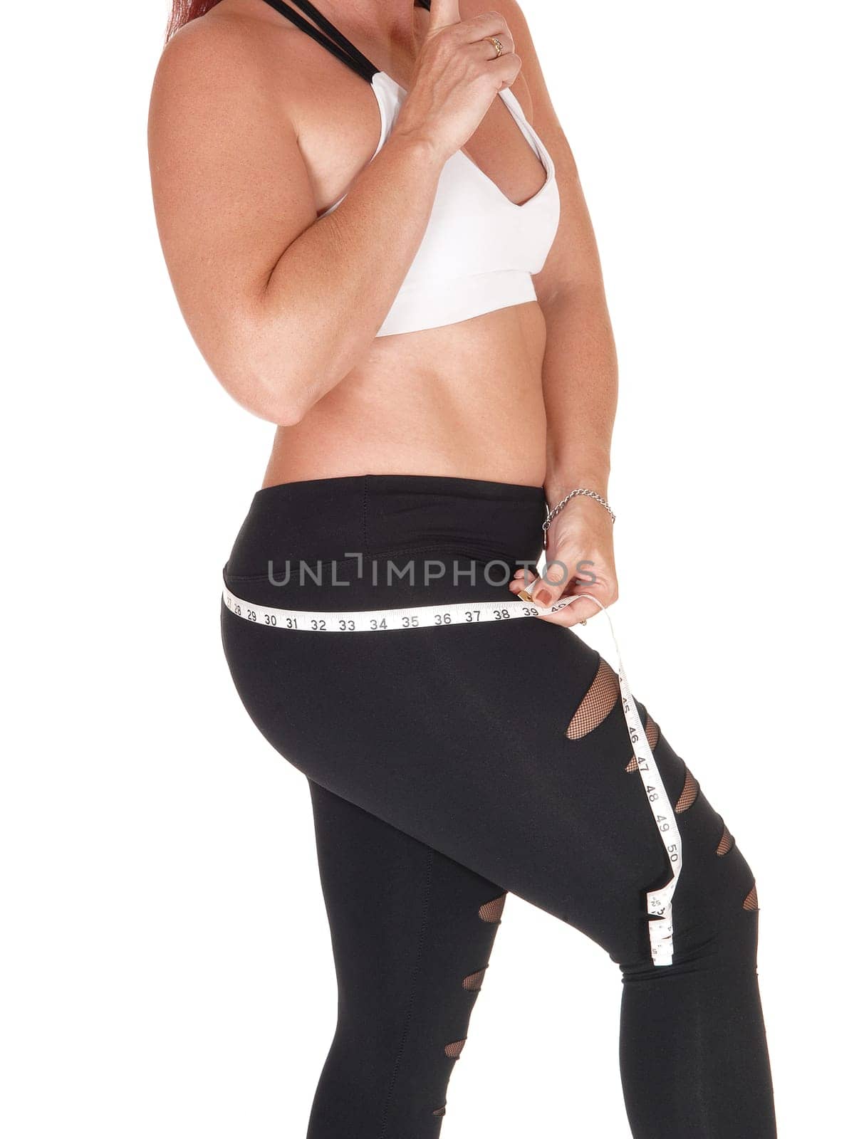 A beautiful woman in sports outfit standing in profile and measuring.her butt, isolated for white background.