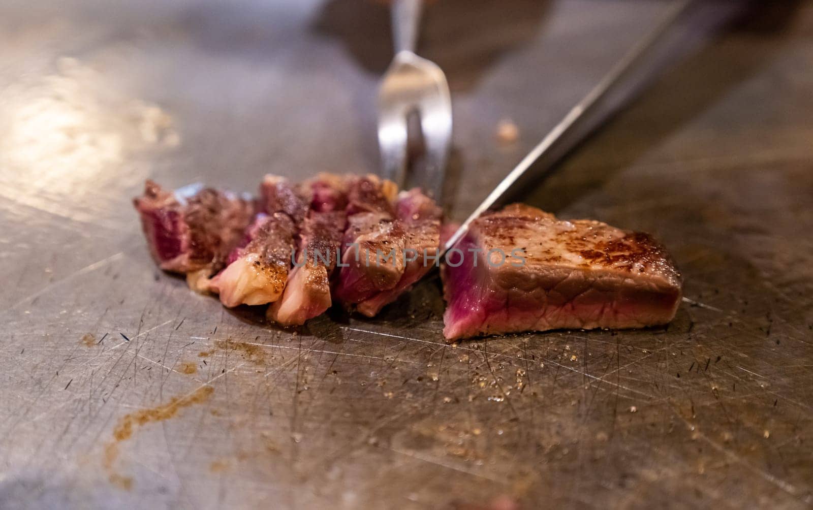 Cooking of beef teppanyaki recipe japanese grilled beef on cooking pan using scraper and knife