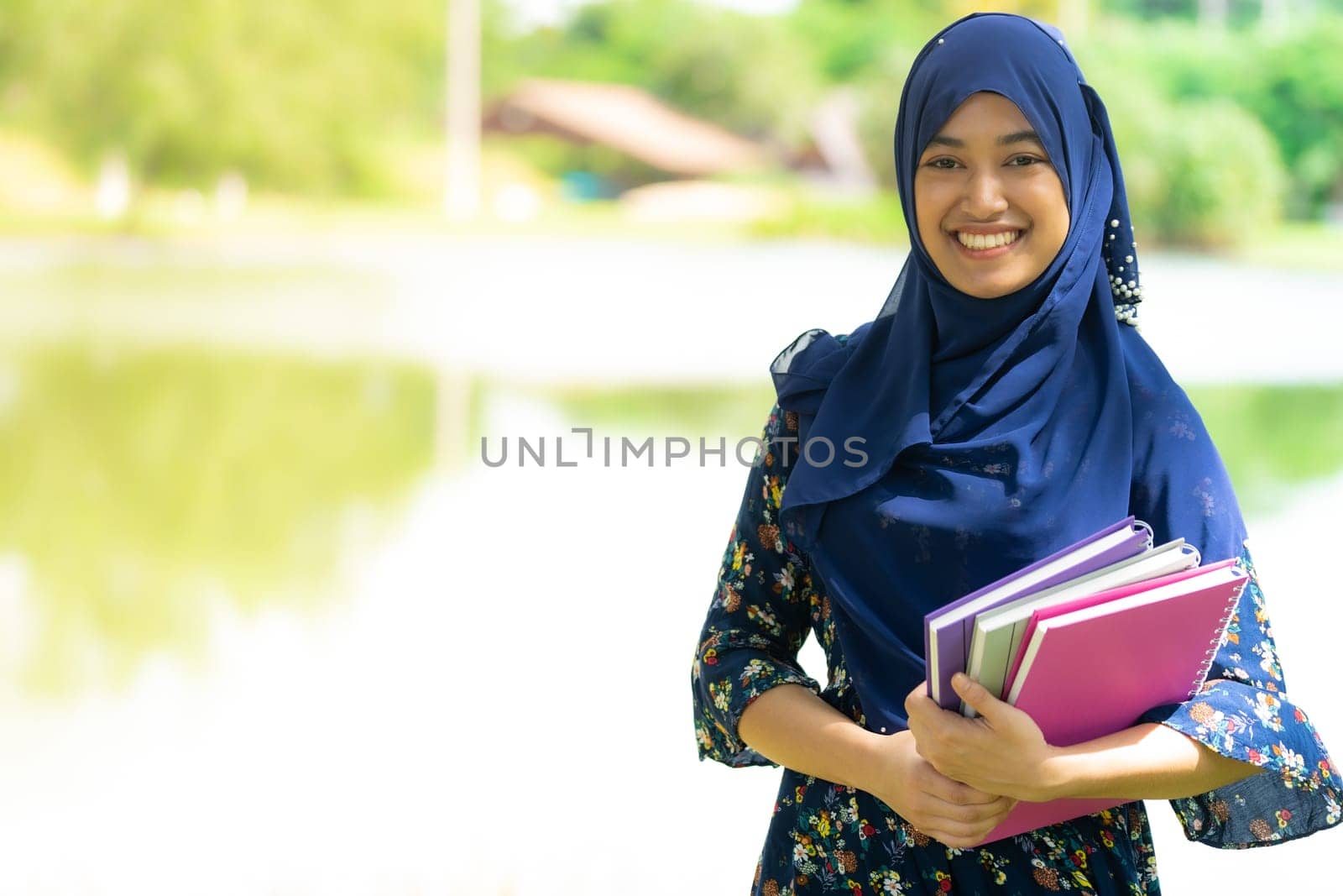 Portrait of good-looking Happy young teenager Muslim islamic asian university girl holding hers books for knowledge and wisdom concept