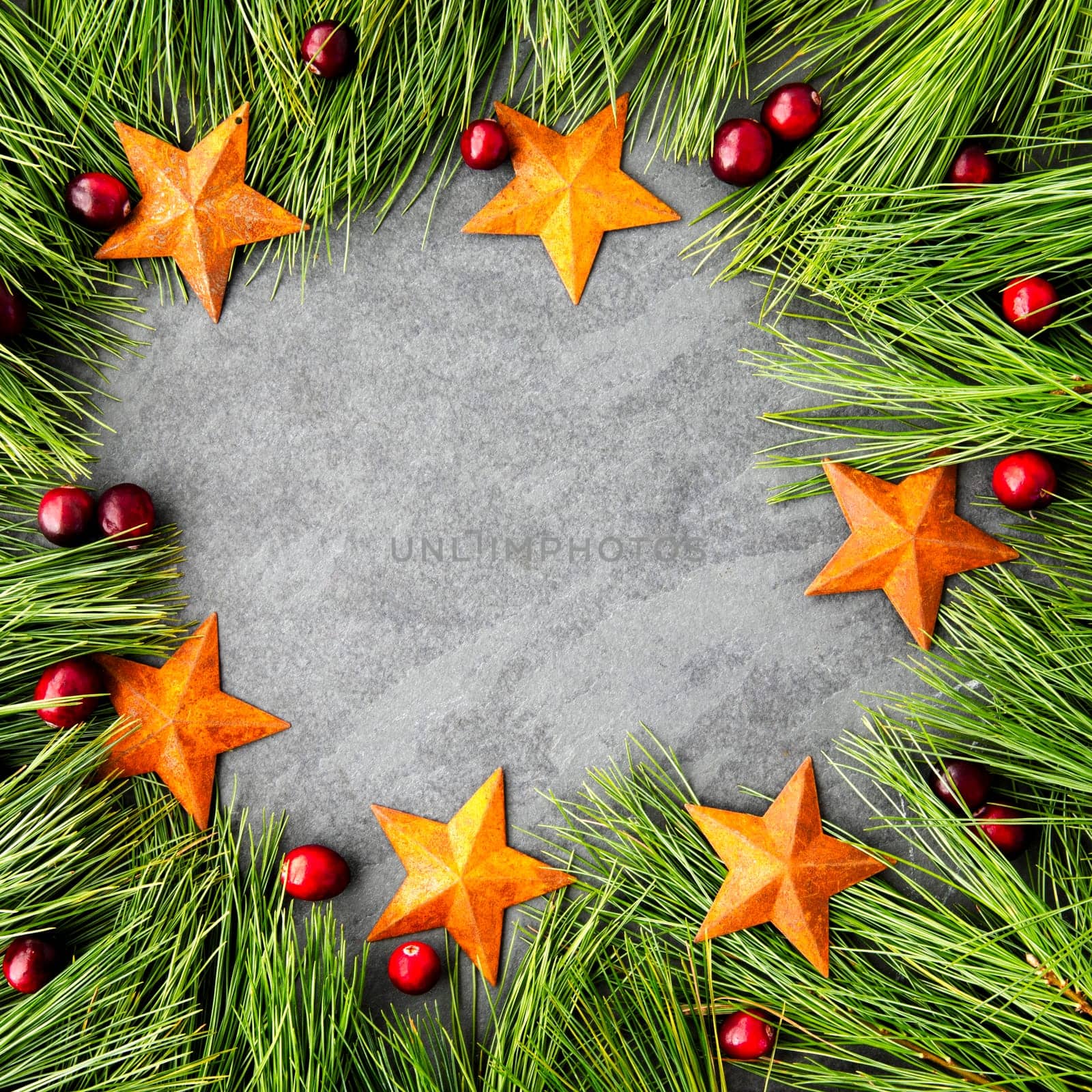 Pine boughs, stars and cranberries rustic Christmas themed frame with slate copy space area. Great for social media.