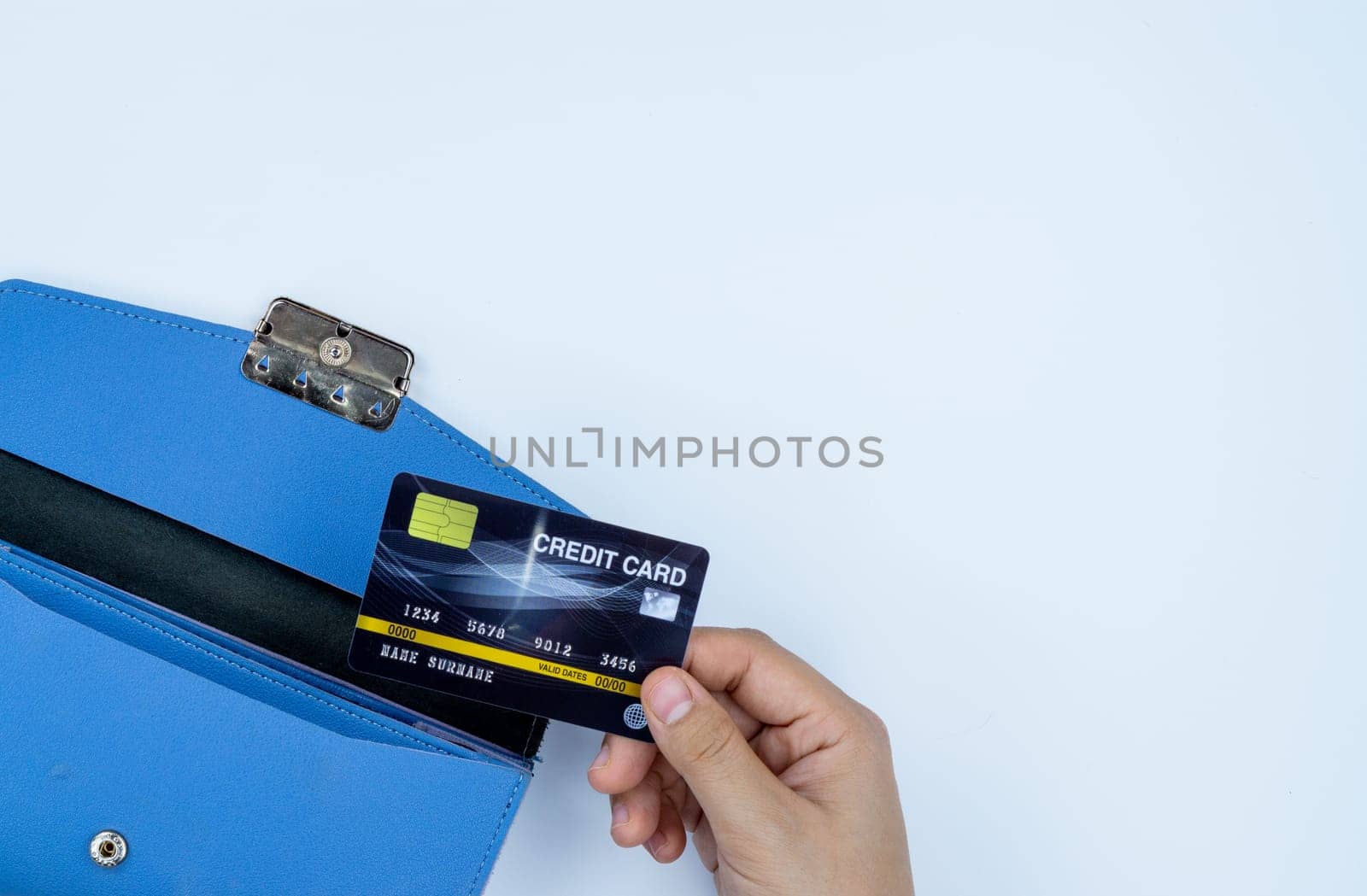 Woman hand taking out the credit card from blue purse for payment on the white background. Finance and money concept, top view, copy space for text.