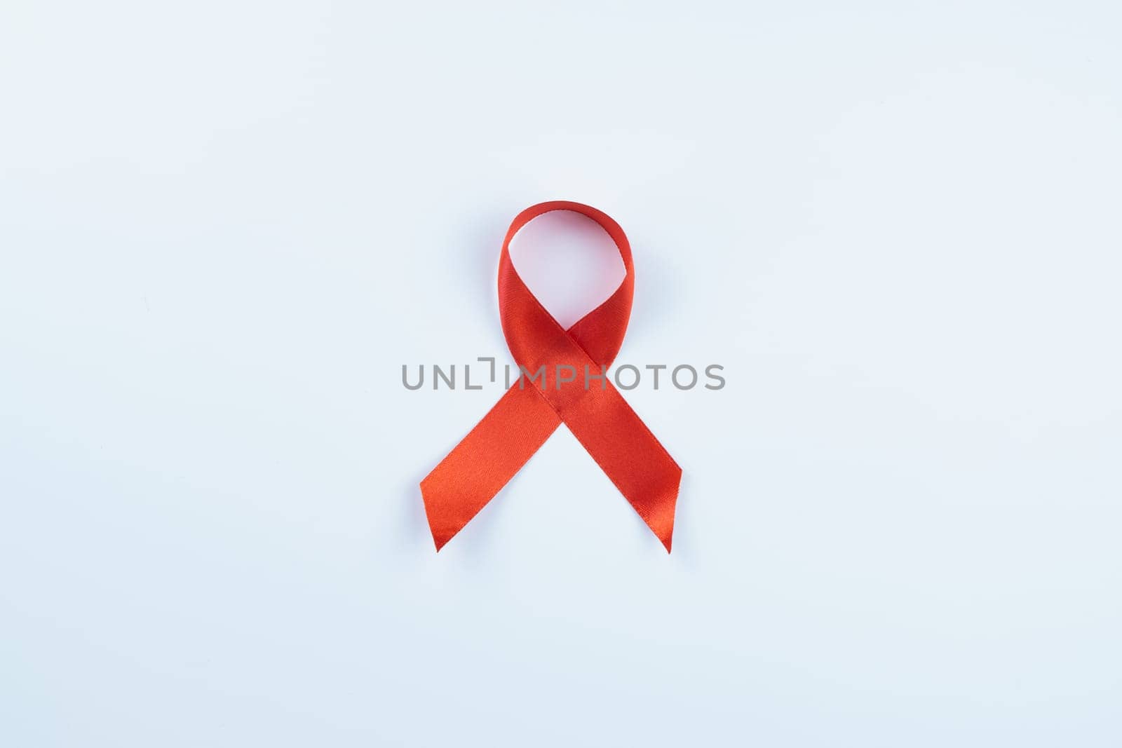 Aids awareness, red ribbon on white background with copy space for text. World Aids Day, Healthcare and medical concept.