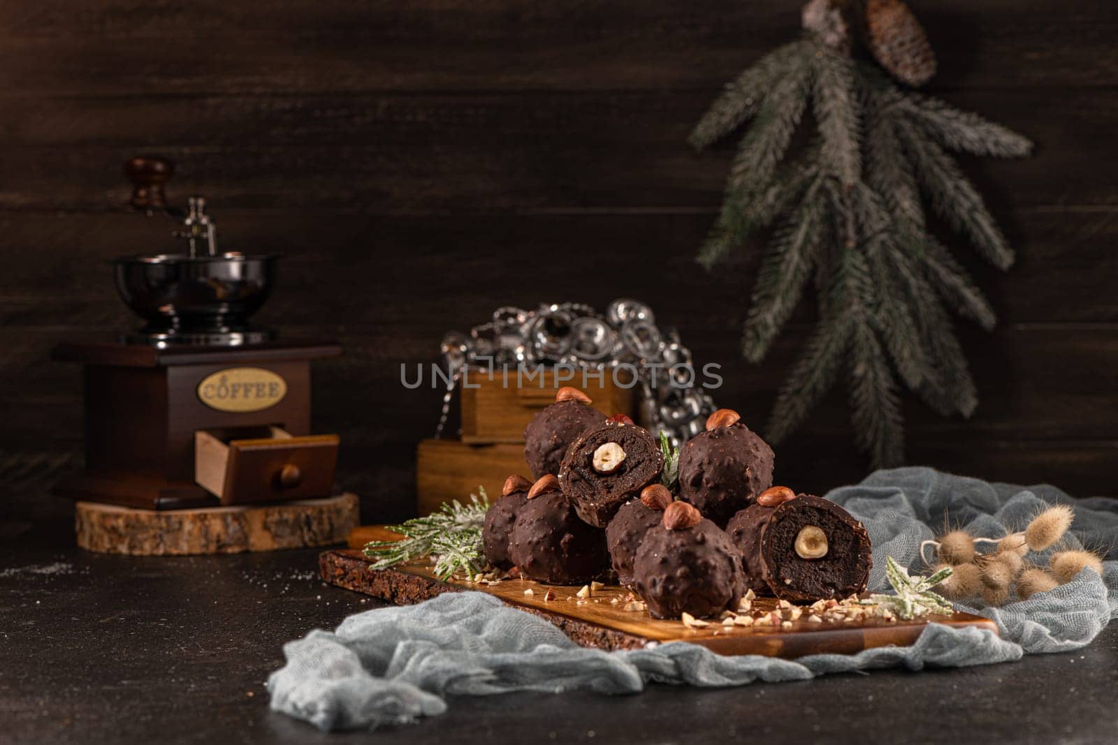 Dark chocolate truffles with hazelnuts over wooden cutting board.