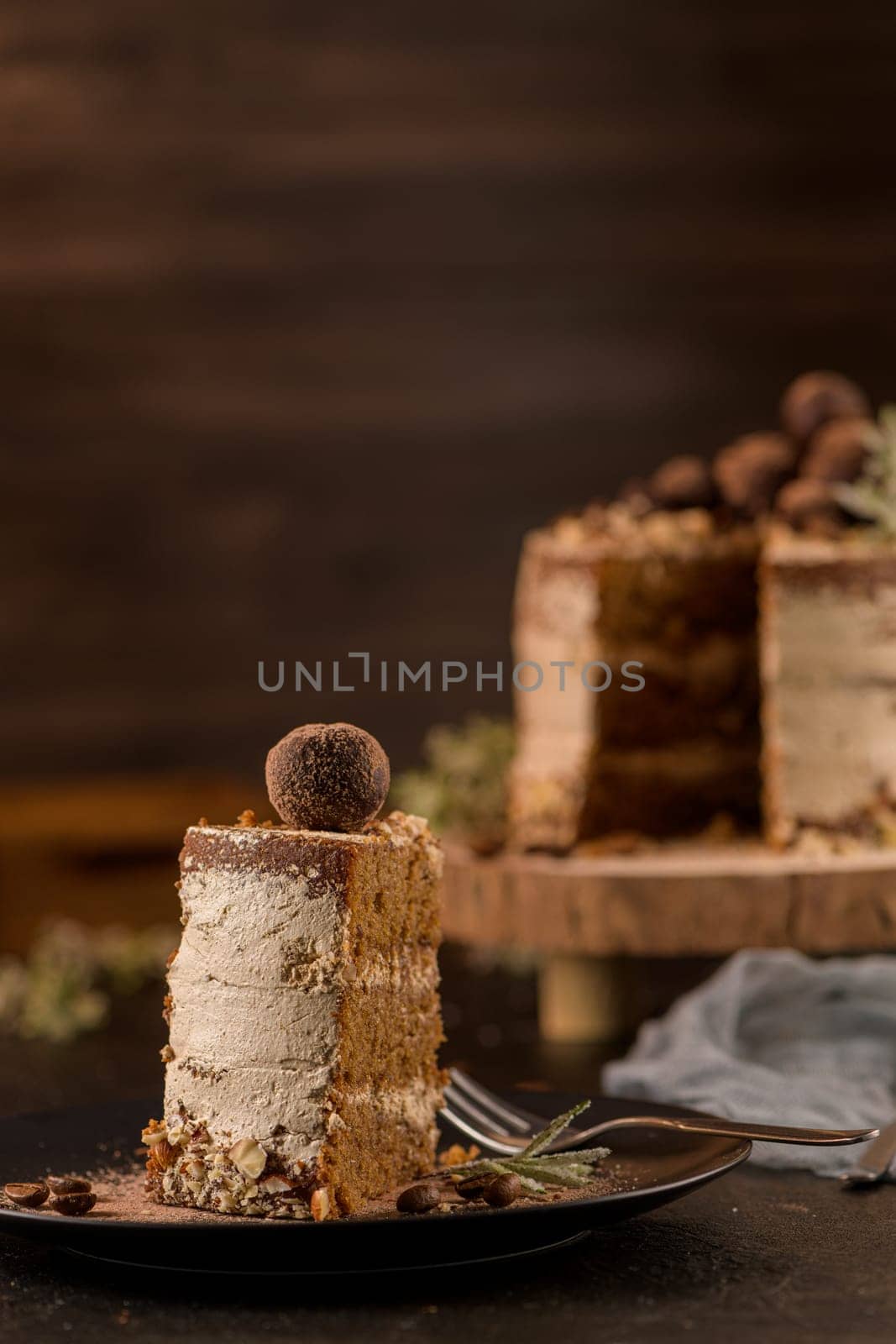 Slice of delicious naked coffee and hazelnuts cake on table rustic wood kitchen countertop.