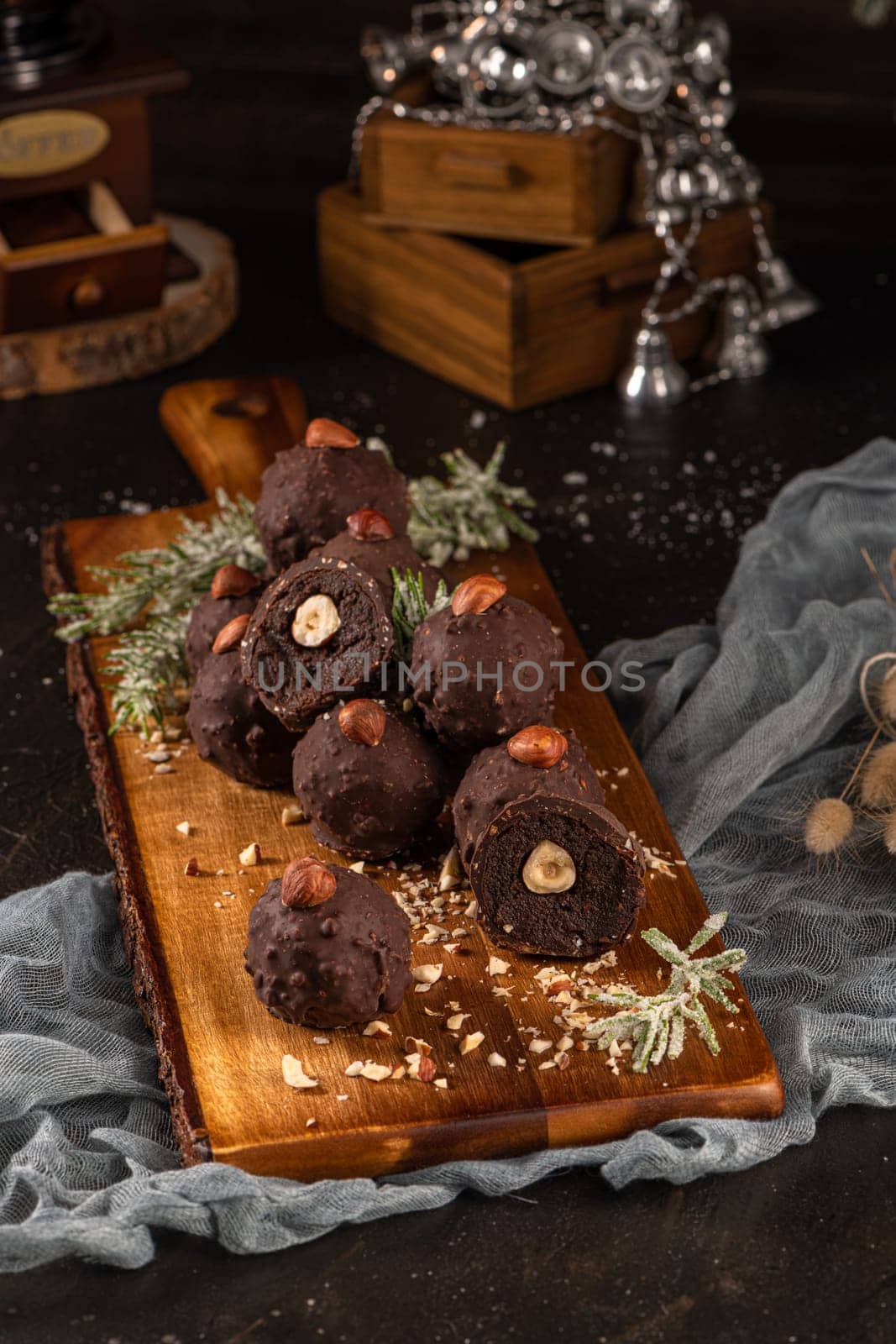 Dark chocolate truffles with hazelnuts over wooden cutting board.