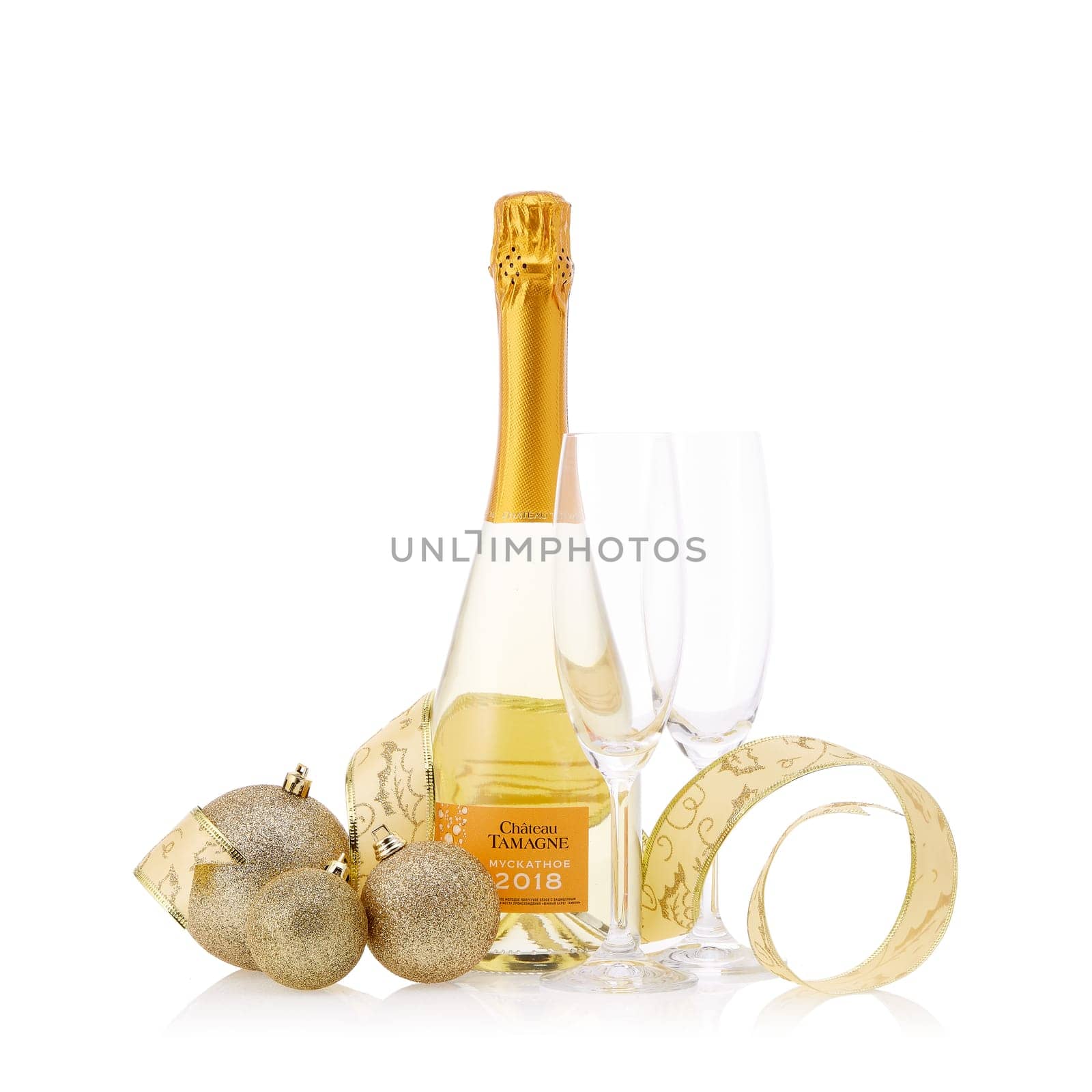 Bottle of muscat white young sparkling wine Chateau Tamagne 2018 and Christmas ornaments isolated on a white background. New Year and Christmas