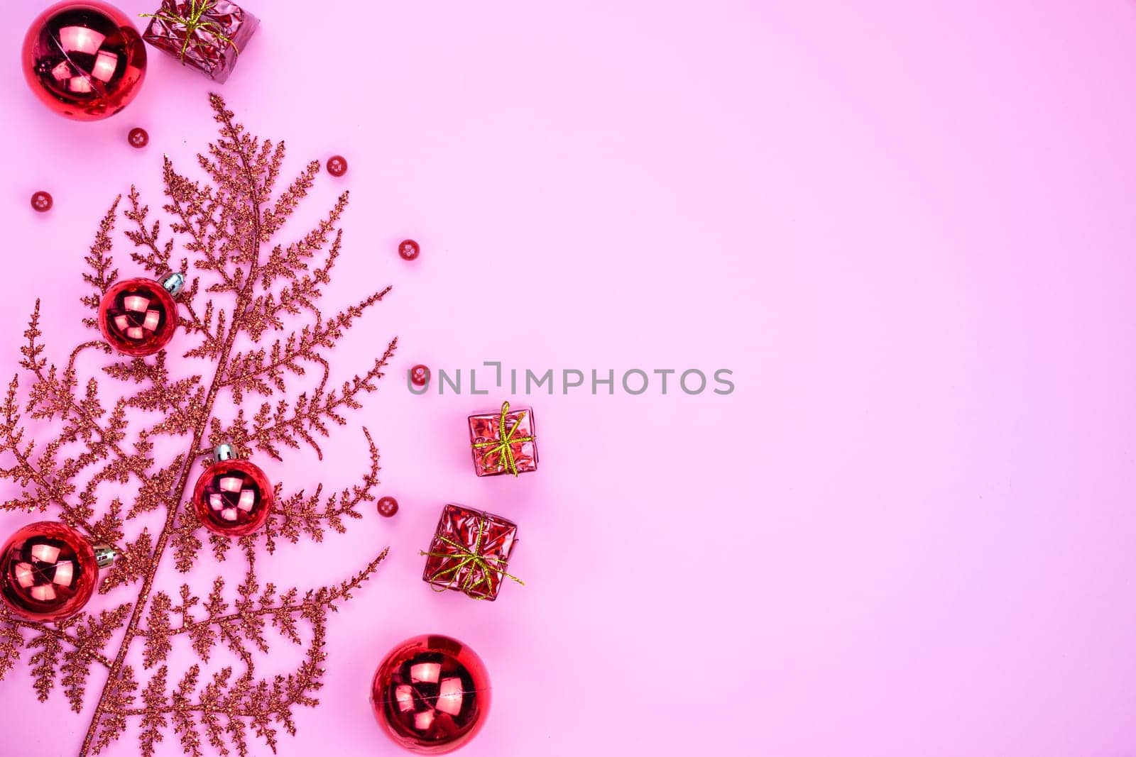 Christmas holidays composition, top view of red Christmas decorations on pink background with copy space for text. Flat lay, winter, postcard template, new year concept.