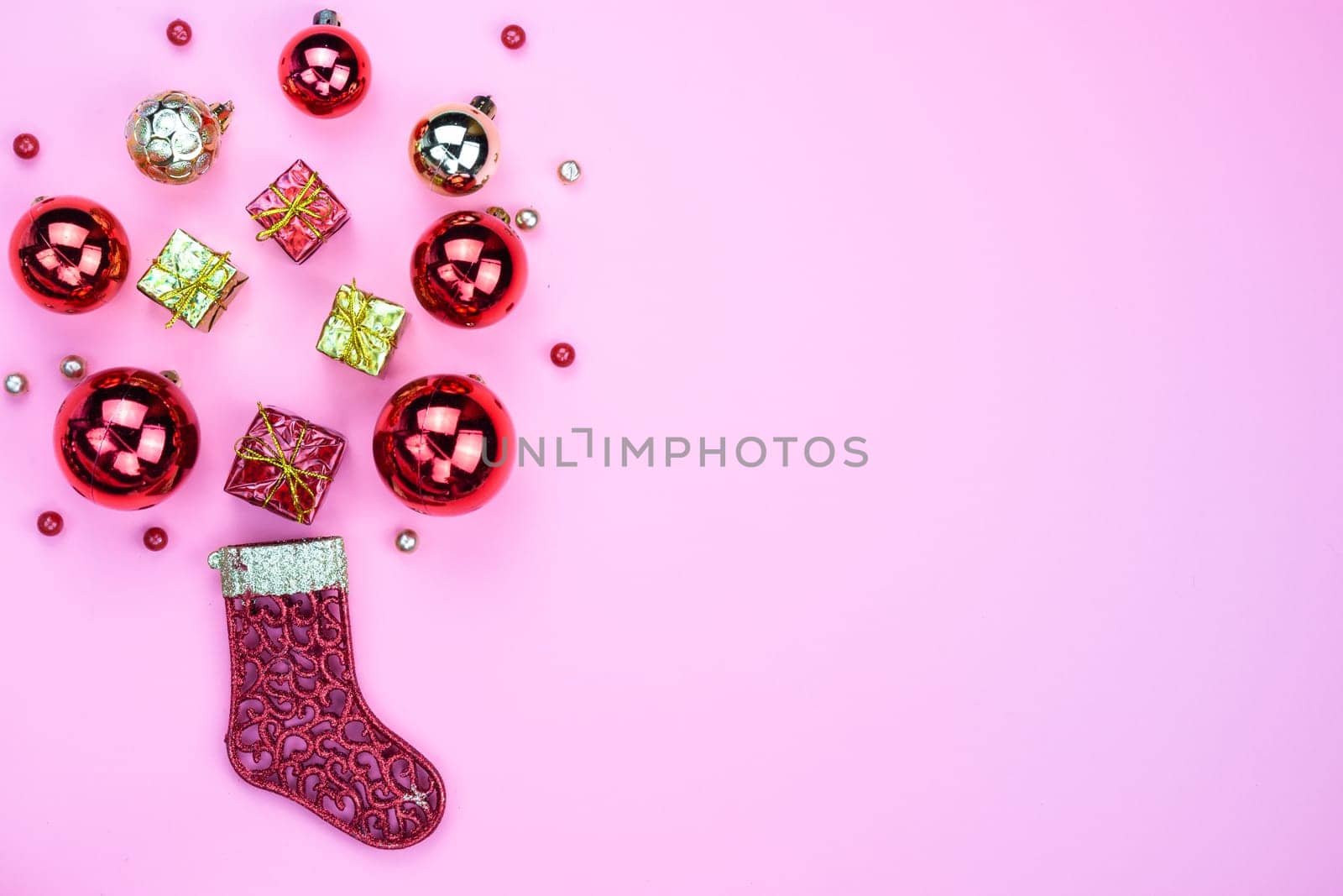Christmas holidays composition, top view of red Christmas decorations on pink background with copy space for text. Flat lay, winter, postcard template, new year concept.