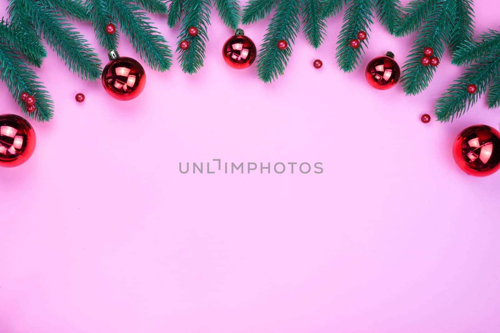 Christmas holidays composition, top view of red Christmas decorations on pink background with copy space for text. Flat lay, winter, postcard template, new year concept.