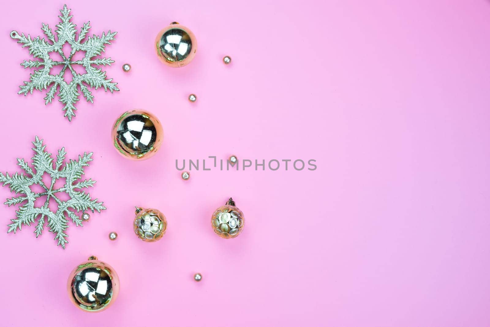 Christmas holidays composition, top view of gold Christmas decorations on pink background with copy space for text. Flat lay, winter, postcard template, new year concept.