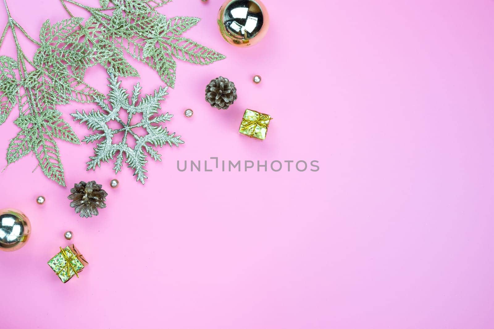 Christmas holidays composition, top view of gold Christmas decorations on pink background with copy space for text. Flat lay, winter, postcard template, new year concept.