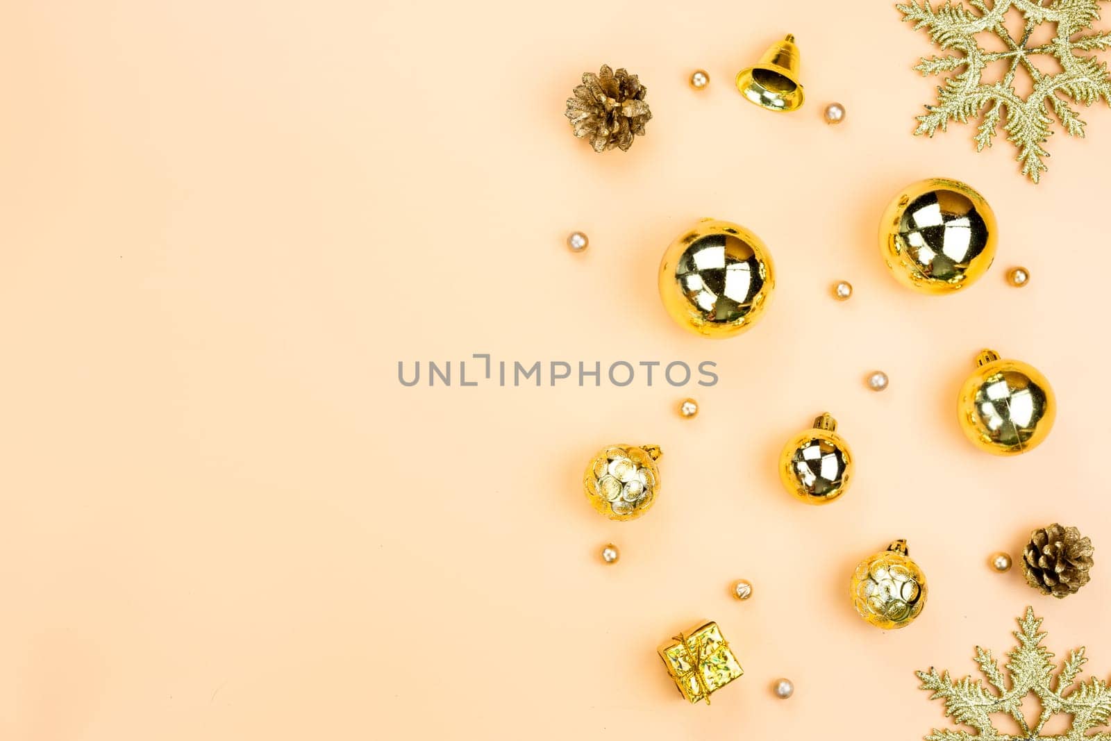 Christmas holidays composition, top view of gold Christmas decorations on yellow background with copy space for text. Flat lay, winter, postcard template, new year concept.