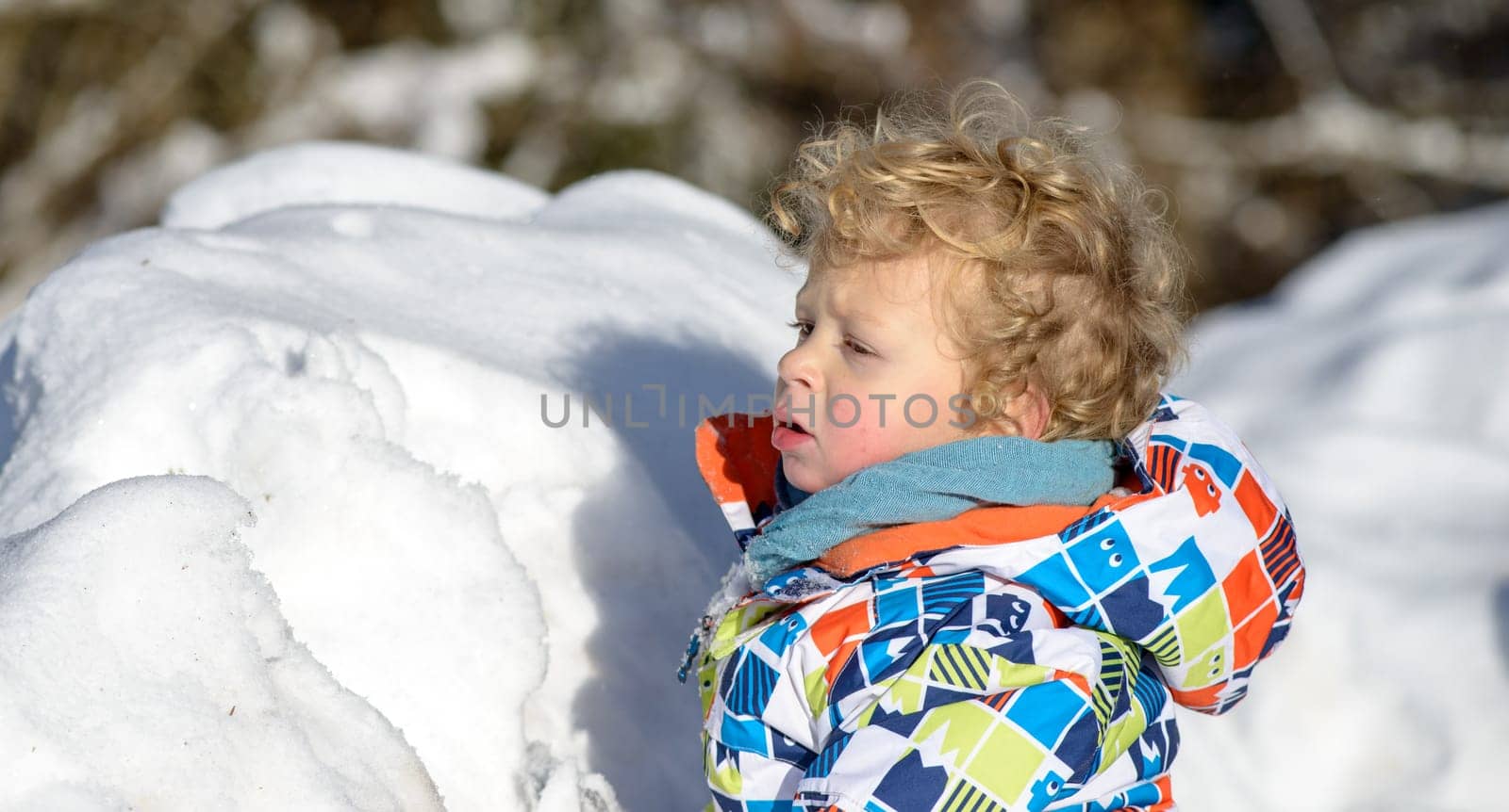 little 3 year old child playing in the snow