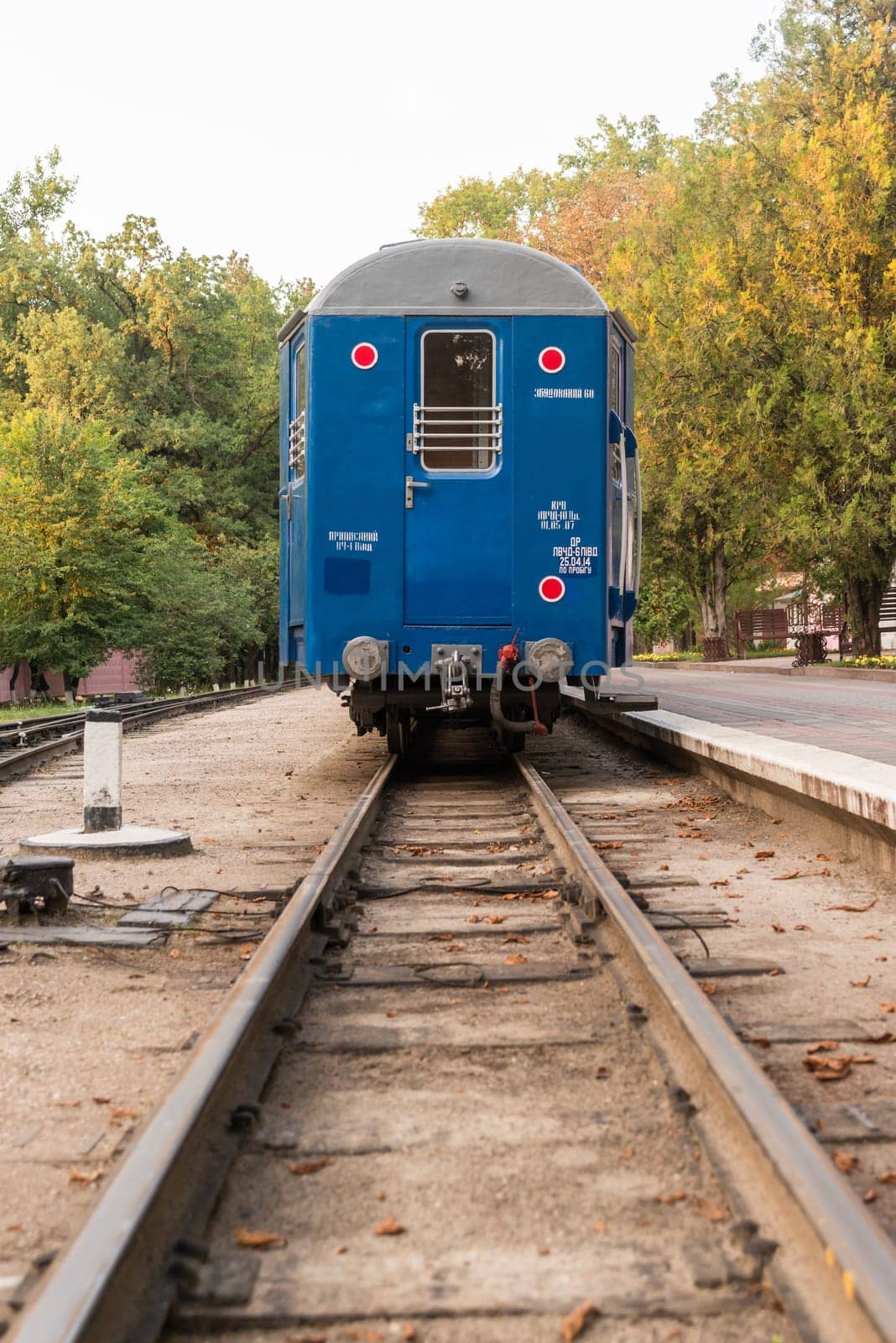 A blue train stopped in station waiting people